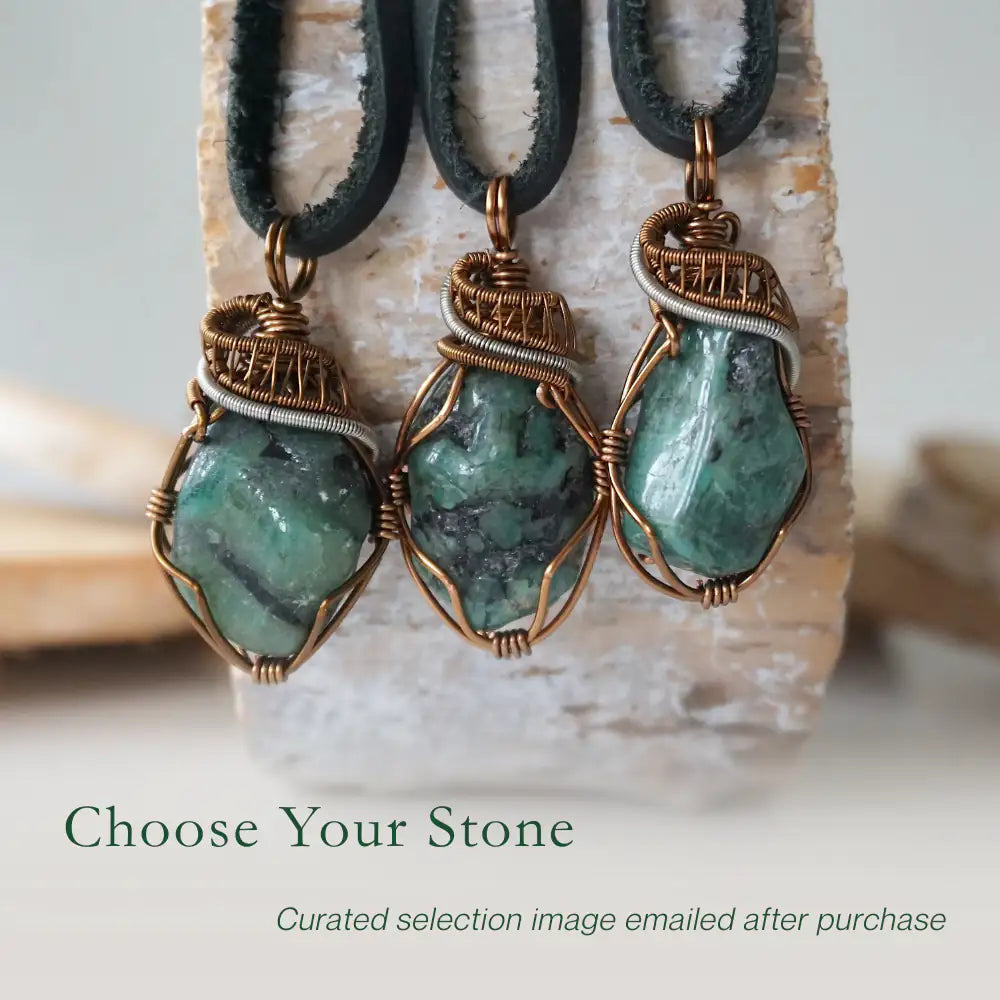 Three raw emerald pendants for men – showing natural variation in size, shape, and green shade, black leather cord.