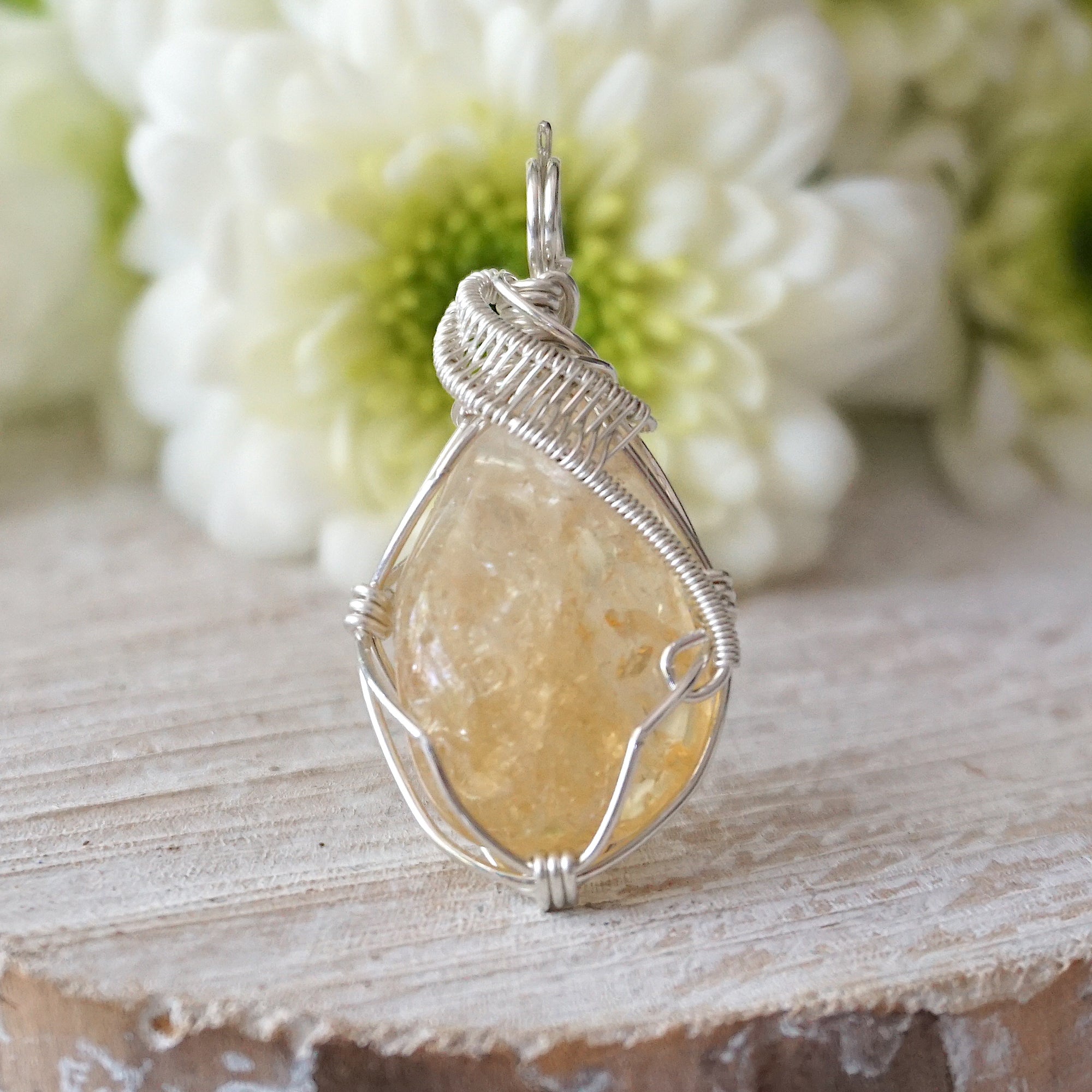 Front view of wire wrapped citrine pendant showing sterling silver wire wrapping detail and natural raw crystal
