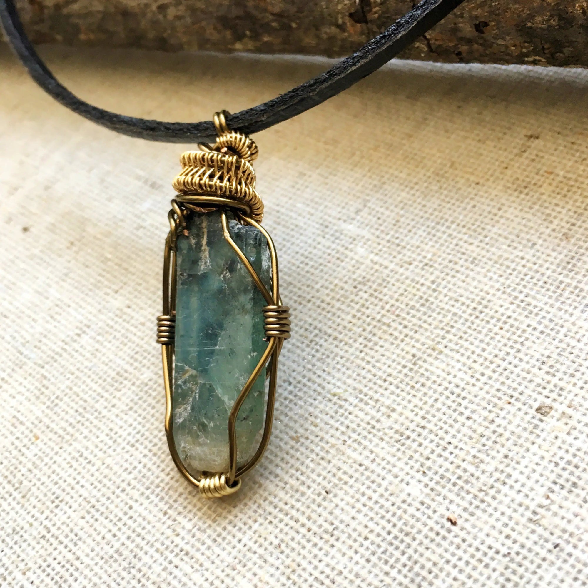 Left angle close-up of green kyanite necklace for men – highlighting unique wire-wrapped artistry, green kyanite, antique bronze and gold copper.