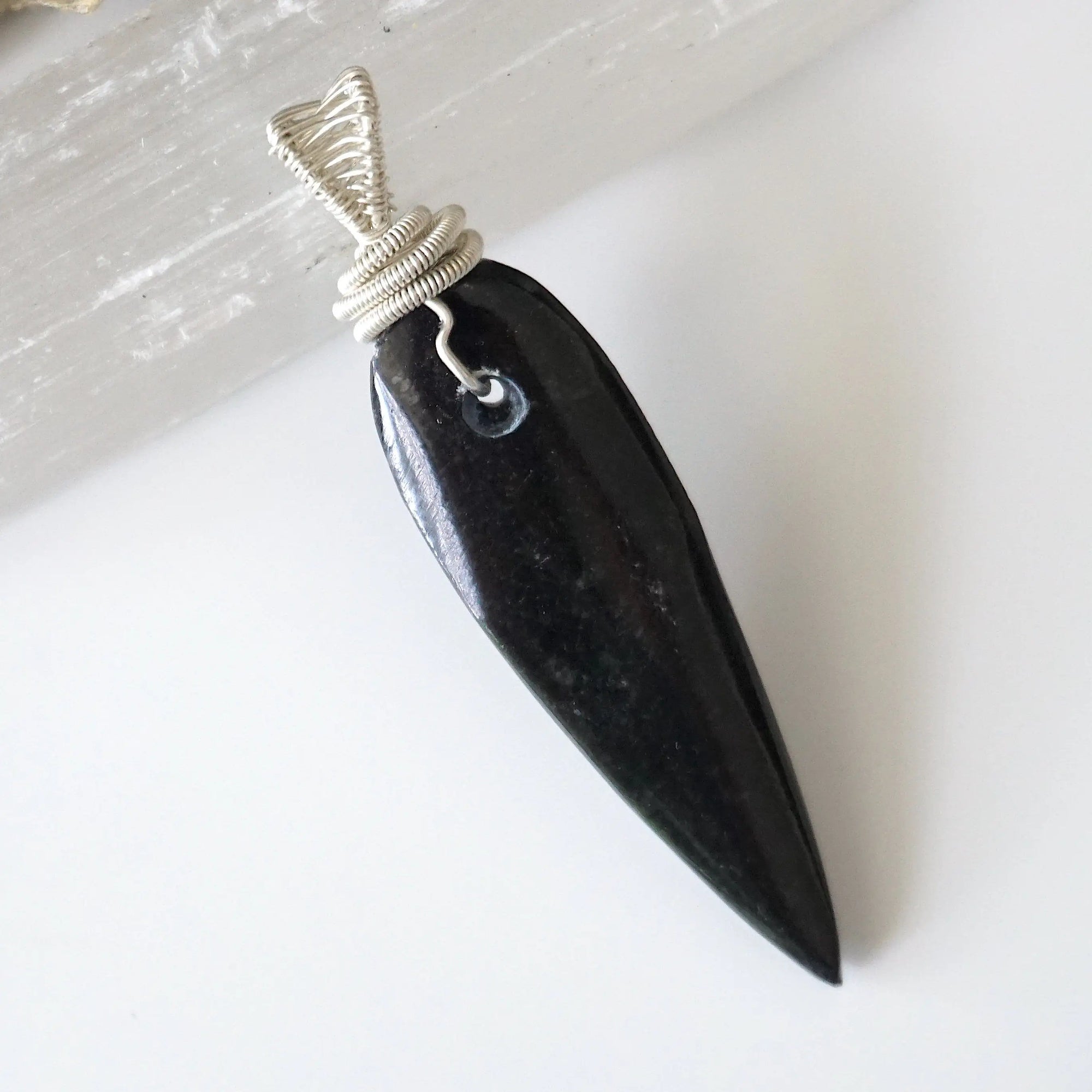 Back view of handcrafted Orthoceras fossil pendant for men – natural fossil pattern and wire wrapping, ancient ocean jewelry.