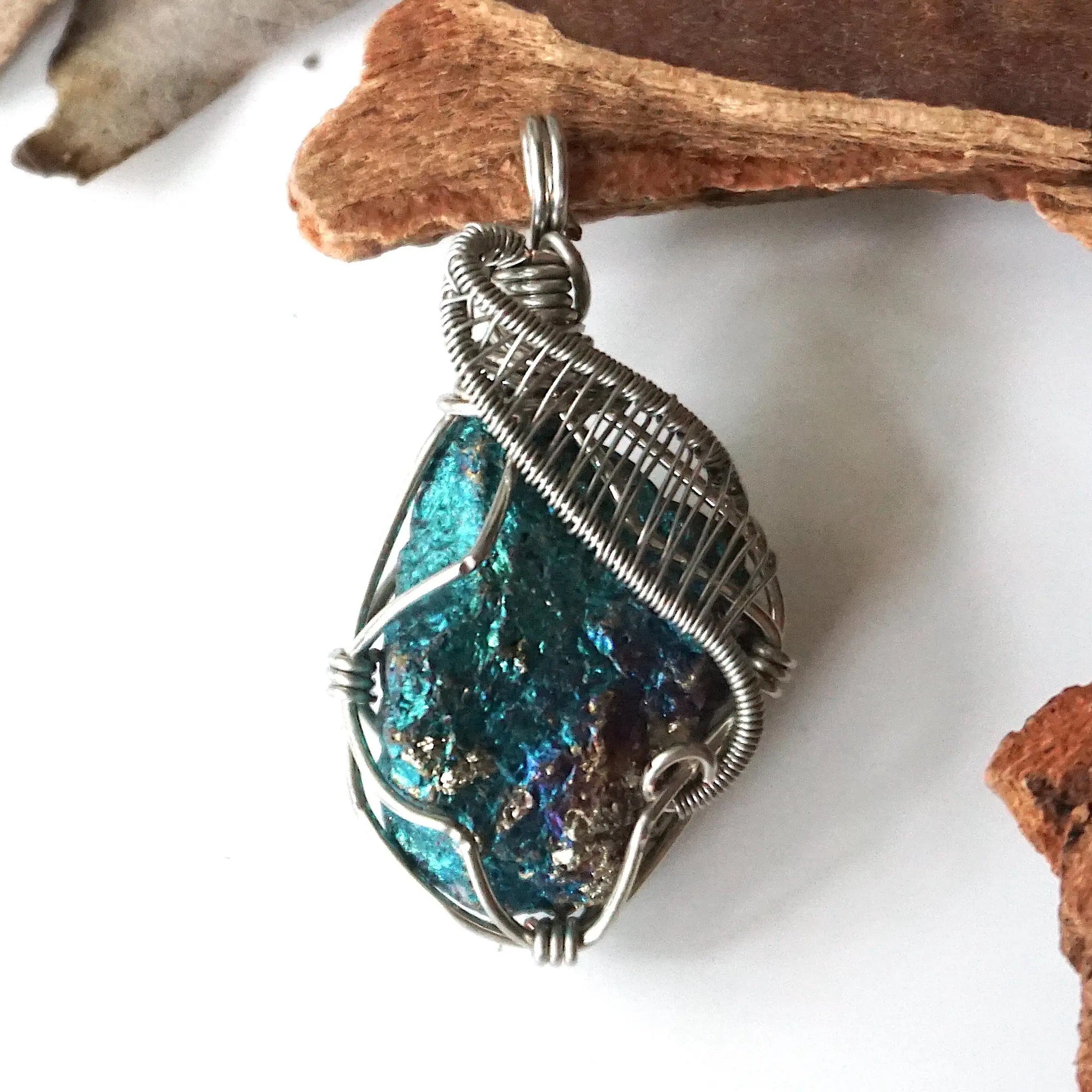 Front angle close-up of peacock ore pendant for men – detailed white gold copper wire wrapping, iridescent crystal, Capricorn and Cancer birthstone.