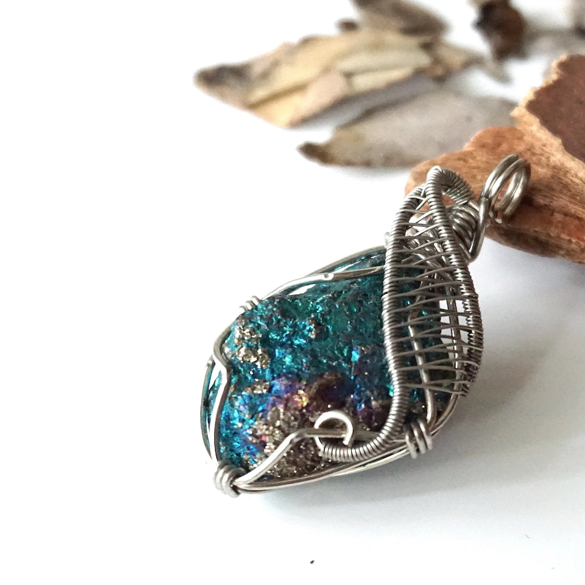 Left angle close-up of peacock ore pendant for men – highlighting unique wire-wrapped artistry, white gold copper, Capricorn and Cancer birthstone.