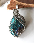 Front angle close-up of peacock ore pendant for women – detailed white gold copper wire wrapping, iridescent crystal, Capricorn and Cancer birthstone.