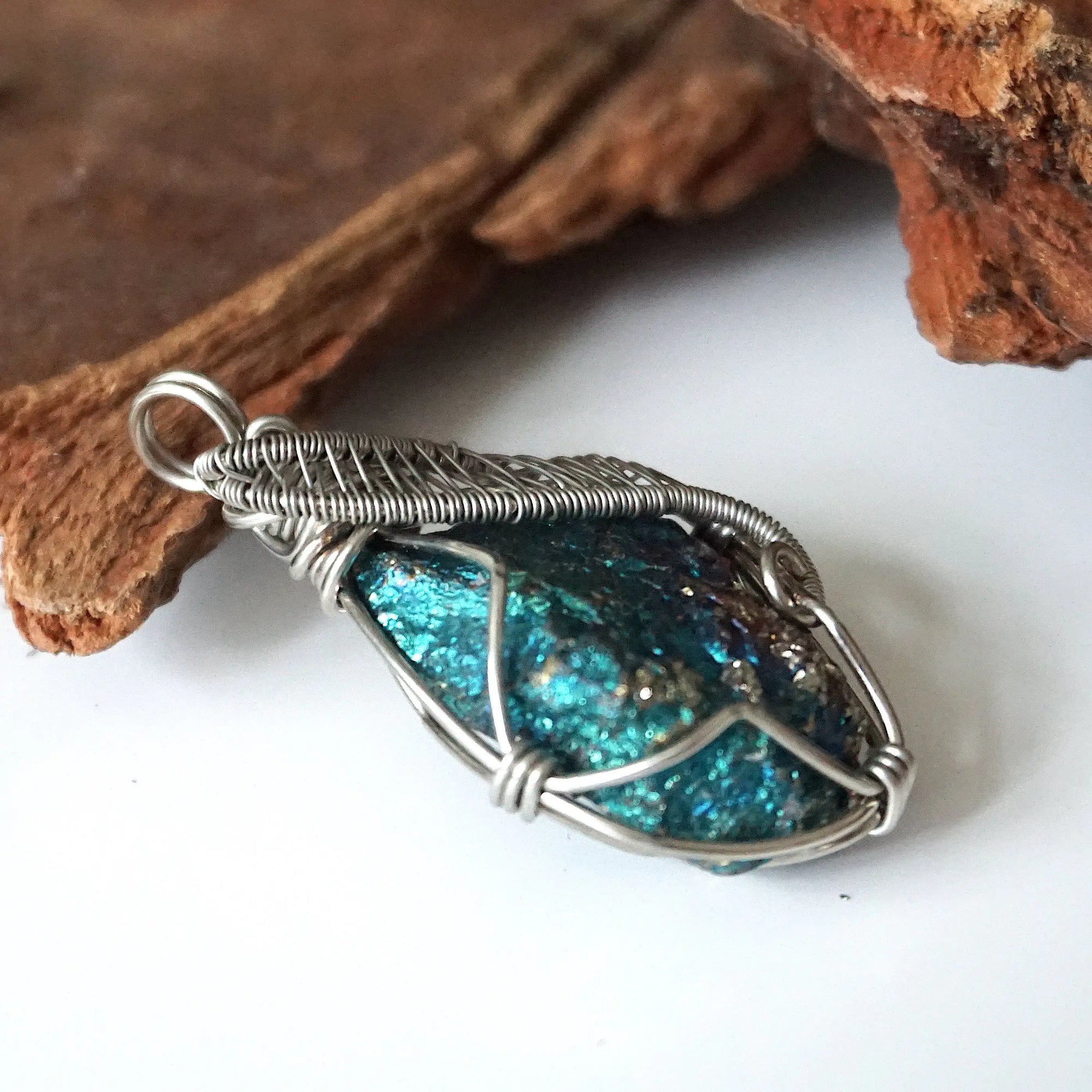 Right angle close-up of peacock ore pendant for women – showcasing artisan wire wrapped white gold copper, natural bornite crystal.