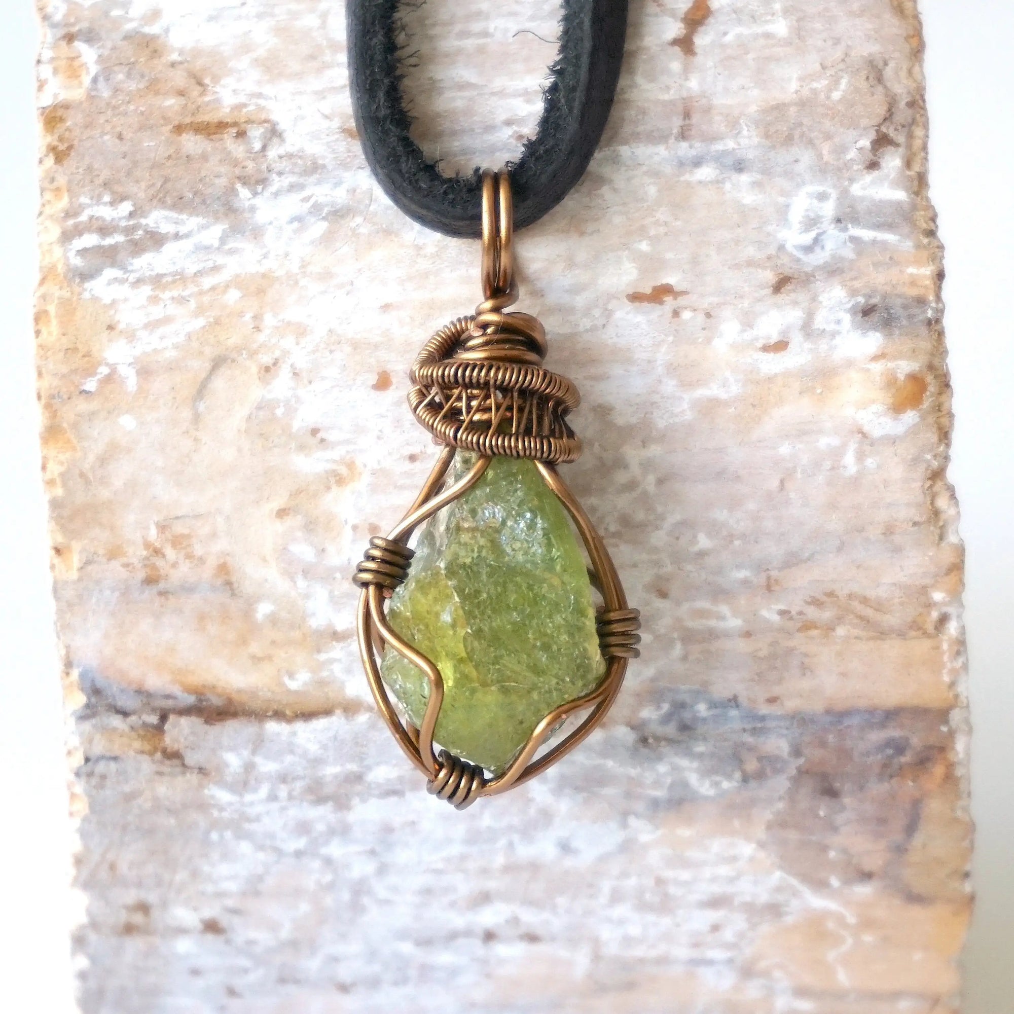Handcrafted raw peridot necklace for men, front view – artisan bronze copper wire wrapping, August birthstone, black leather cord.