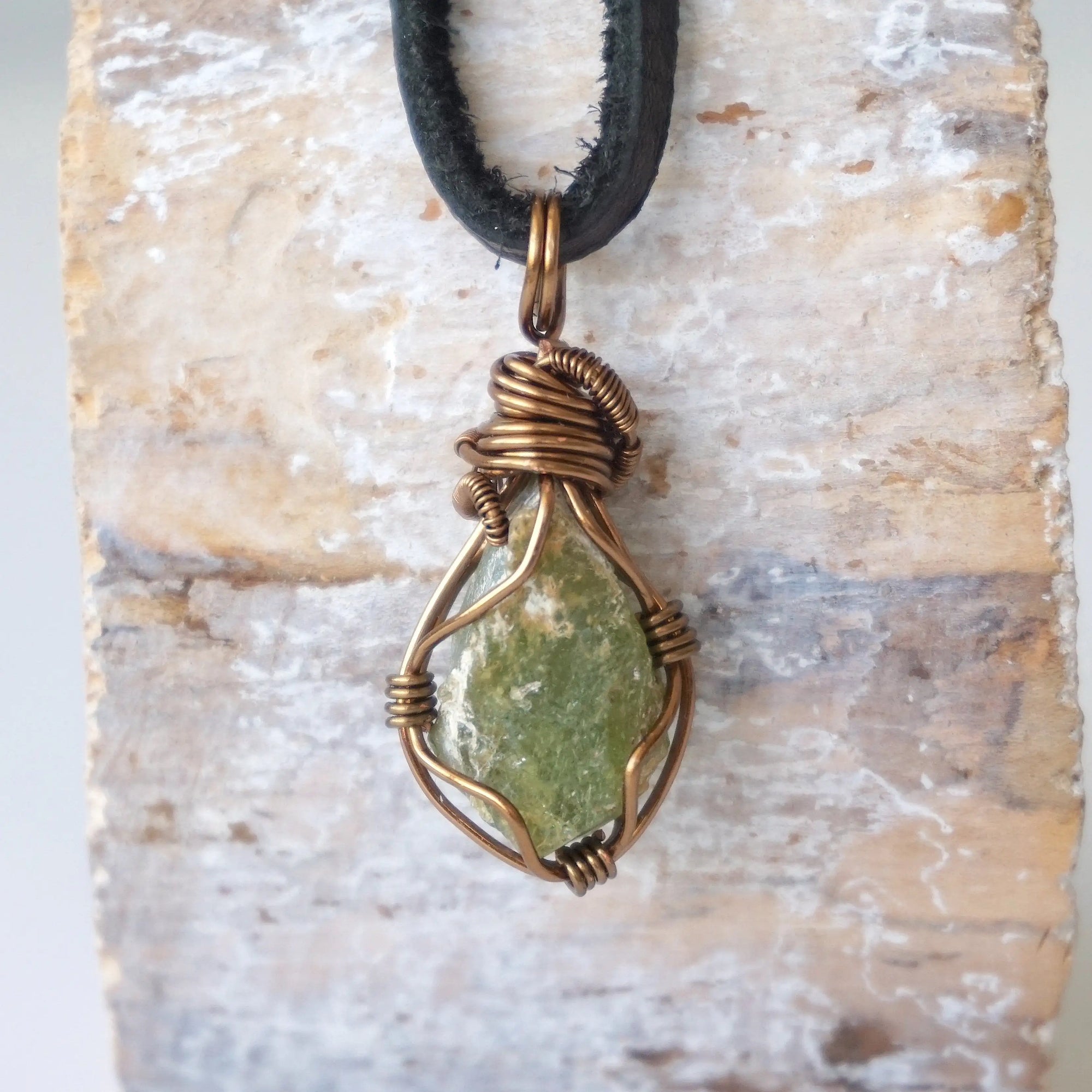 Back view of handcrafted men's peridot necklace – natural stone and wire wrapping, August birthstone, black leather cord.