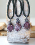 Three raw ruby pendants for men – showing natural variation in size, shape, and red shade, black leather cord.