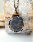 Handcrafted raw sapphire necklace, front view – artisan bronze copper wire wrapping, September birthstone jewelry for all genders, Designs by Nature Gems.