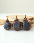 Three raw sapphire pendants – showing natural variation in size, shape, and blue shade, handcrafted unisex birthstone jewelry.