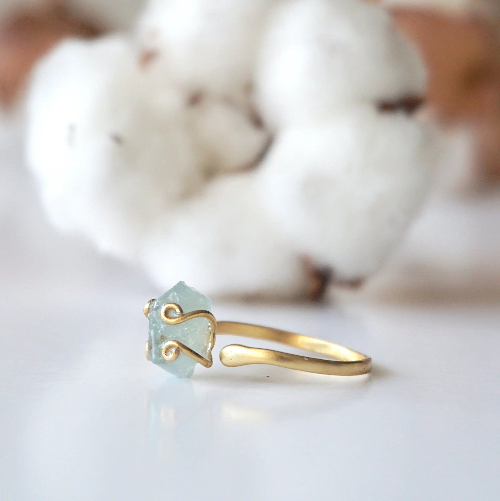 Left side angle of adjustable aquamarine ring, showing raw aquamarine and open band in 14k gold vermeil