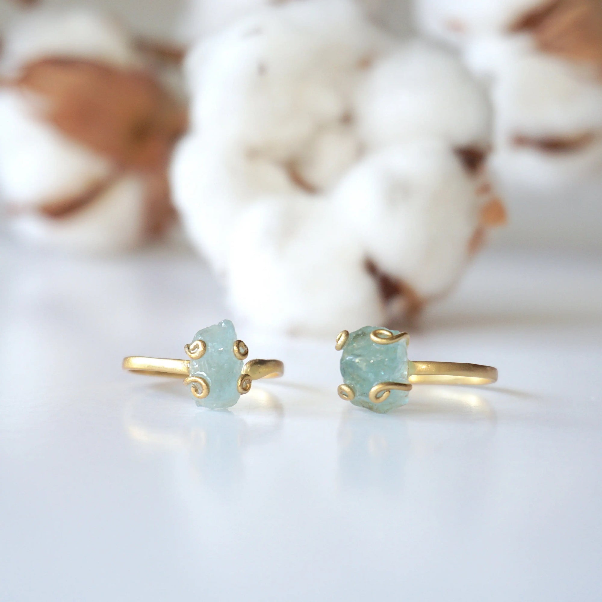 Two adjustable aquamarine rings side by side, showing natural variation in aquamarine's size, shape, and color, 14k gold vermeil
