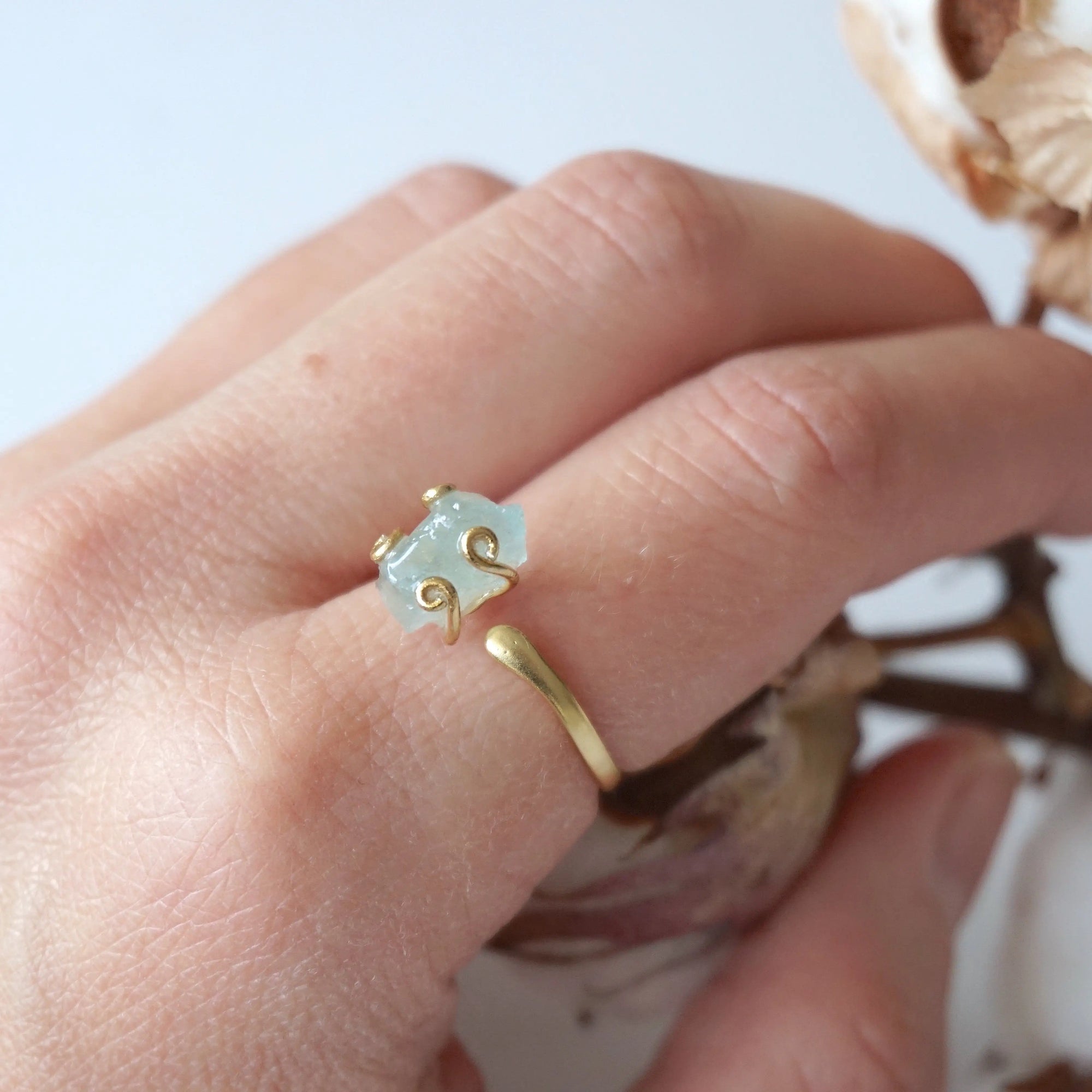 Adjustable aquamarine ring with raw gemstone in 14k gold vermeil prong setting on female model's hand, Designs by Nature Gems