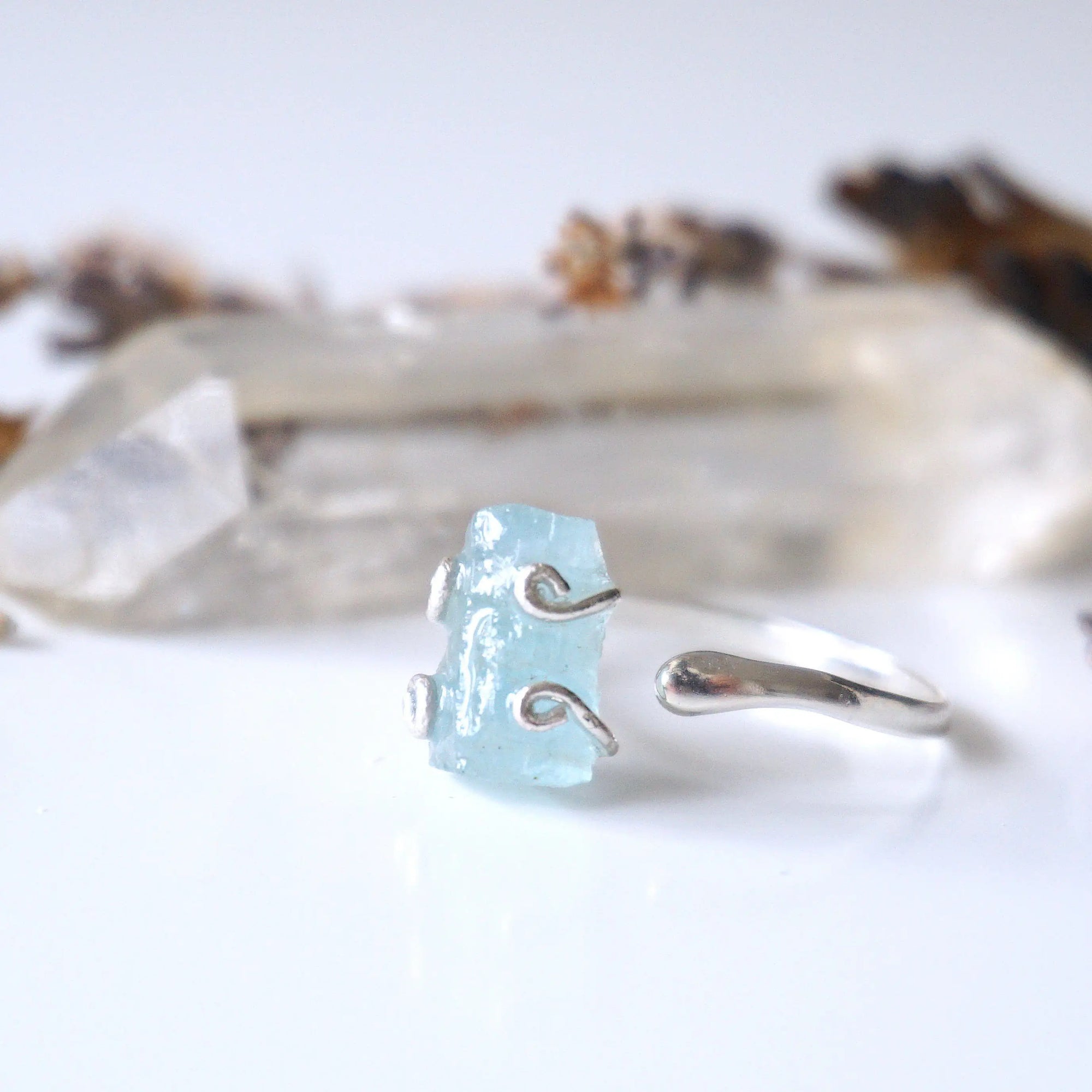 Left side angle of adjustable aquamarine ring, showing raw aquamarine and open band in 925 sterling silver
