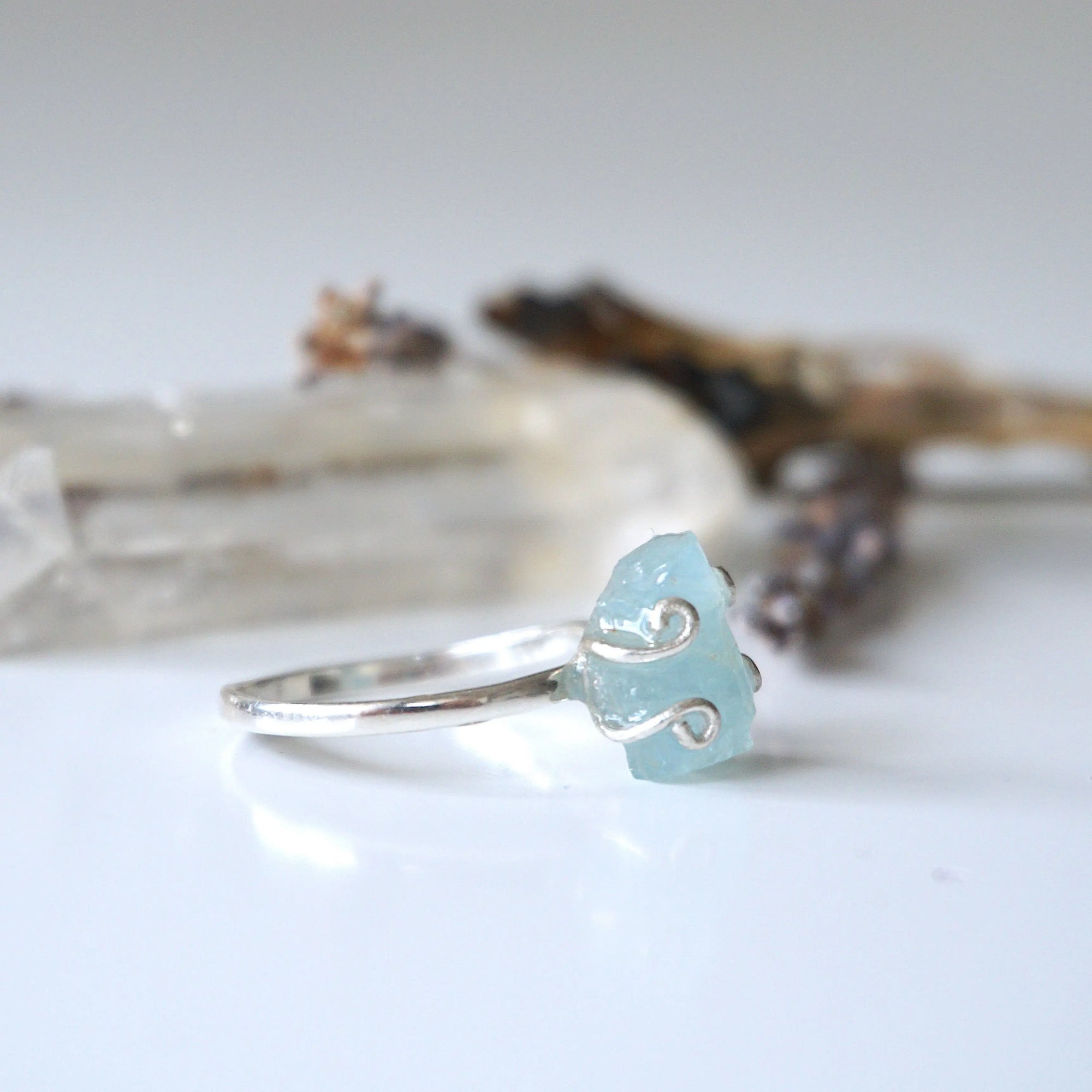 Right angle view of adjustable aquamarine ring, highlighting prong setting and raw gemstone, 925 sterling silver