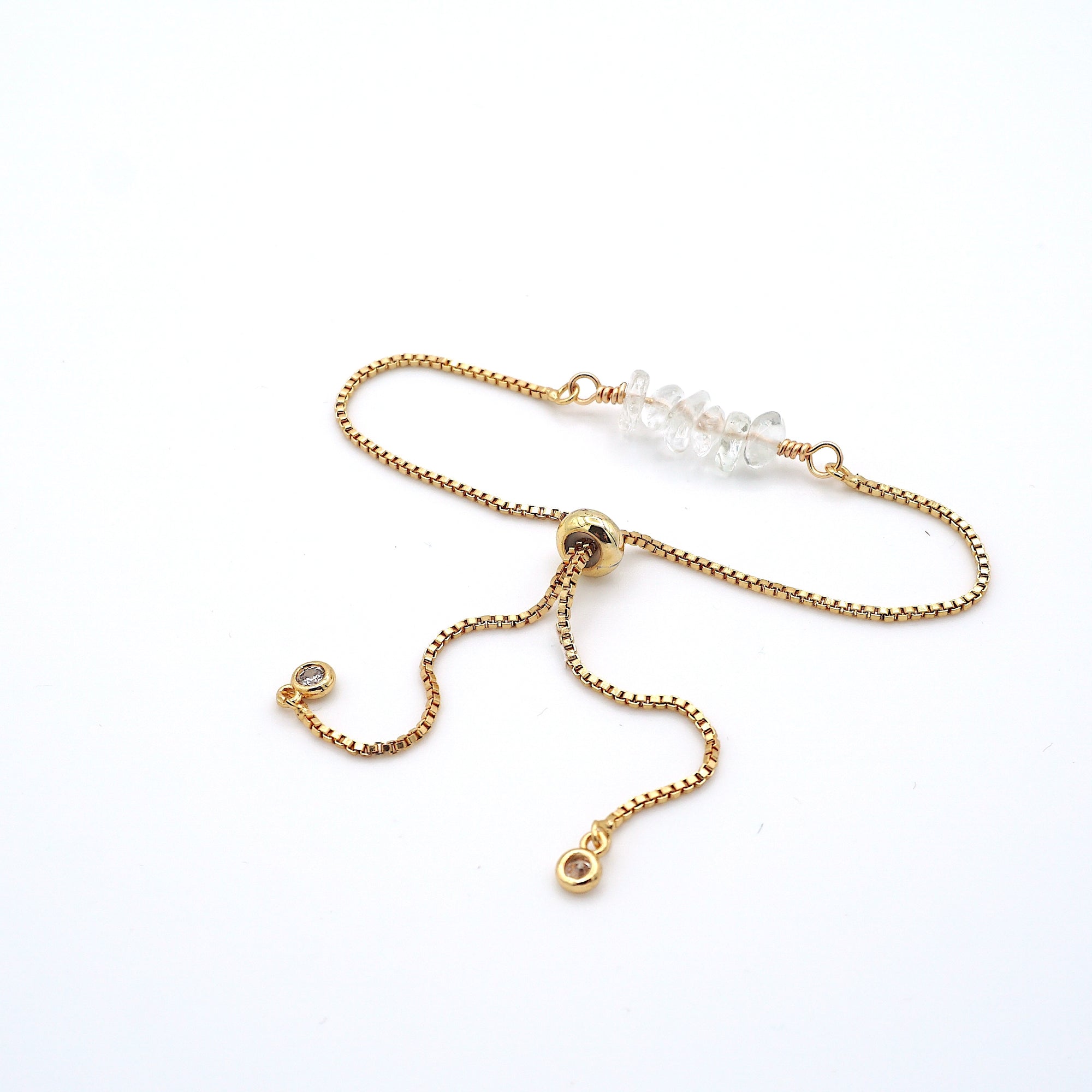 Gold plated brass slider closure on adjustable clear quartz bracelet showing easy fit mechanism - handcrafted birthstone jewelry