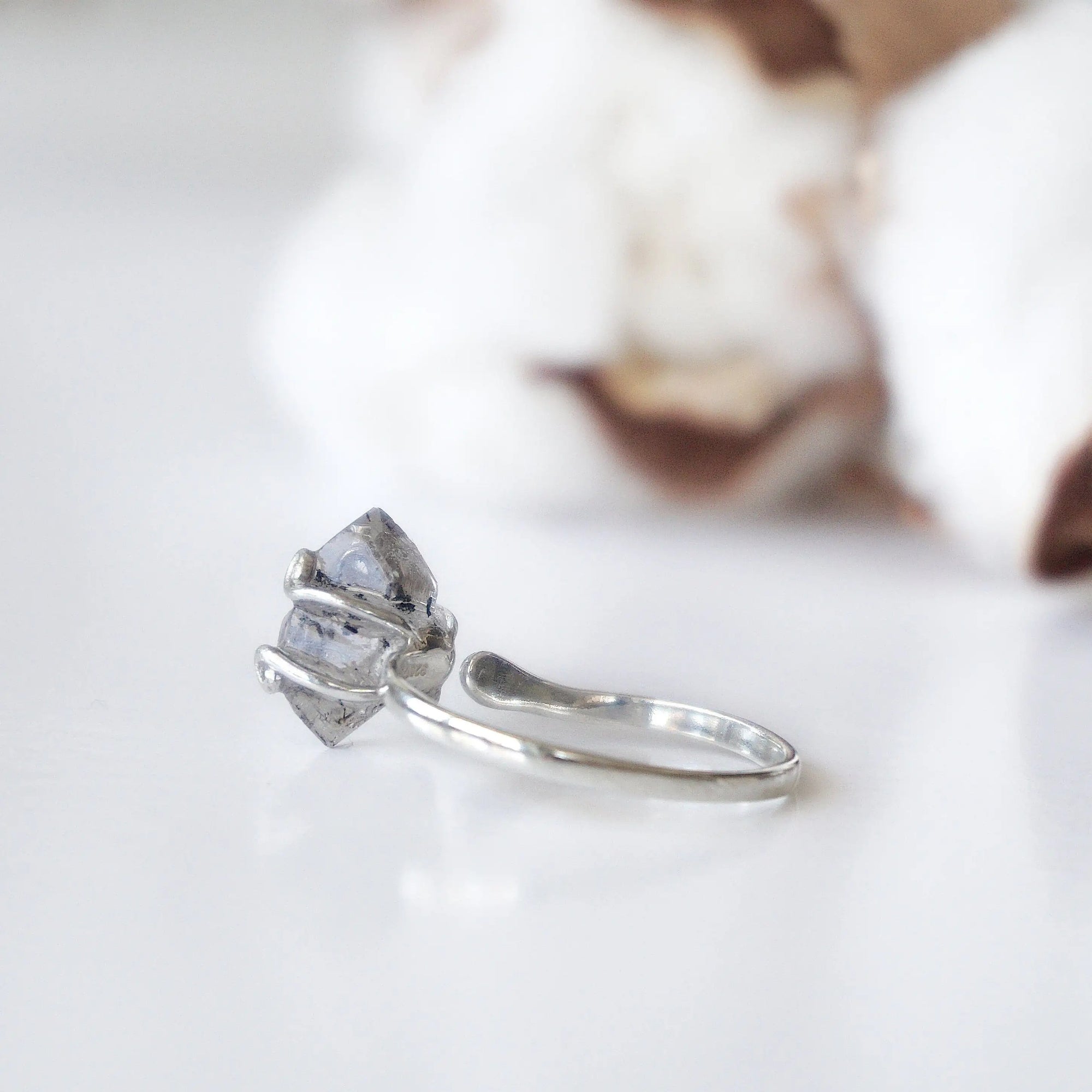 Back view of adjustable raw Herkimer diamond ring showing the ring band and handcrafted sterling silver setting.