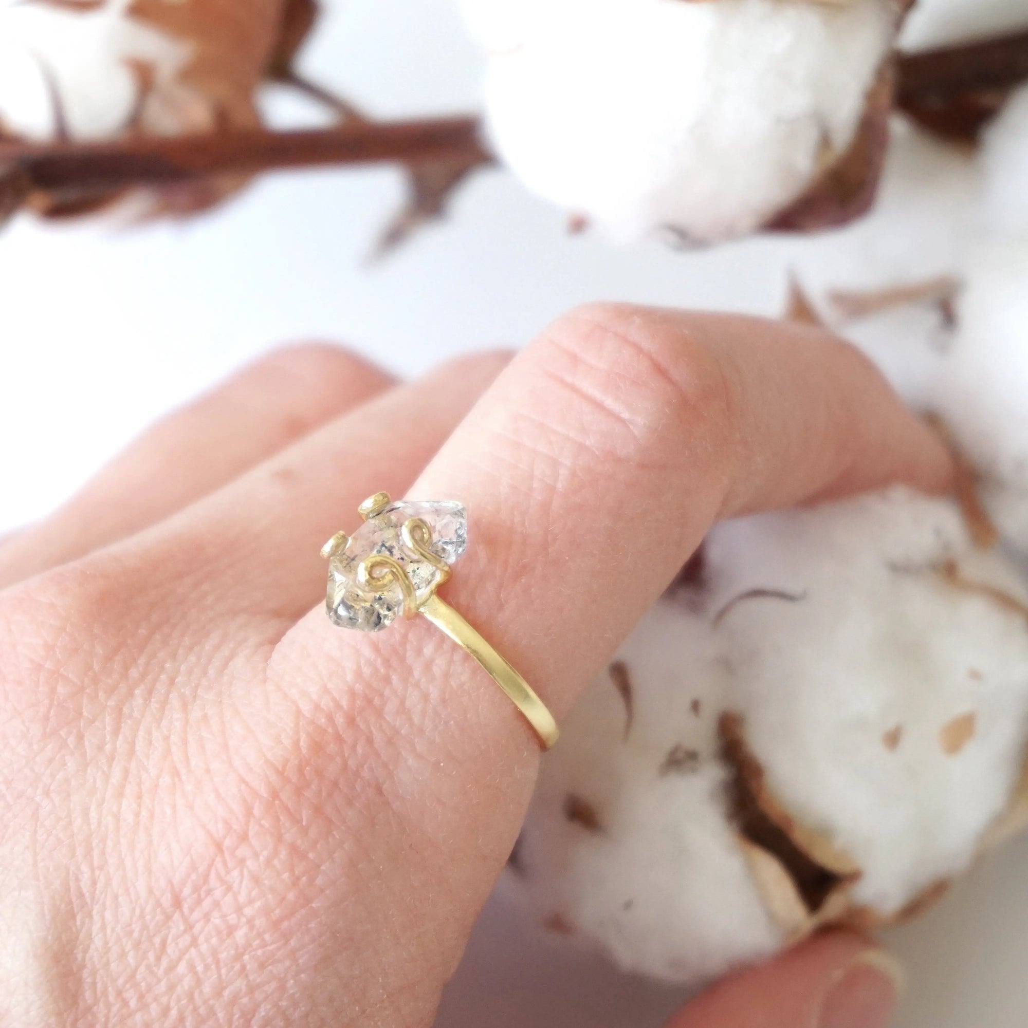 Adjustable raw Herkimer diamond ring in 14k gold vermeil worn on a female model’s hand.