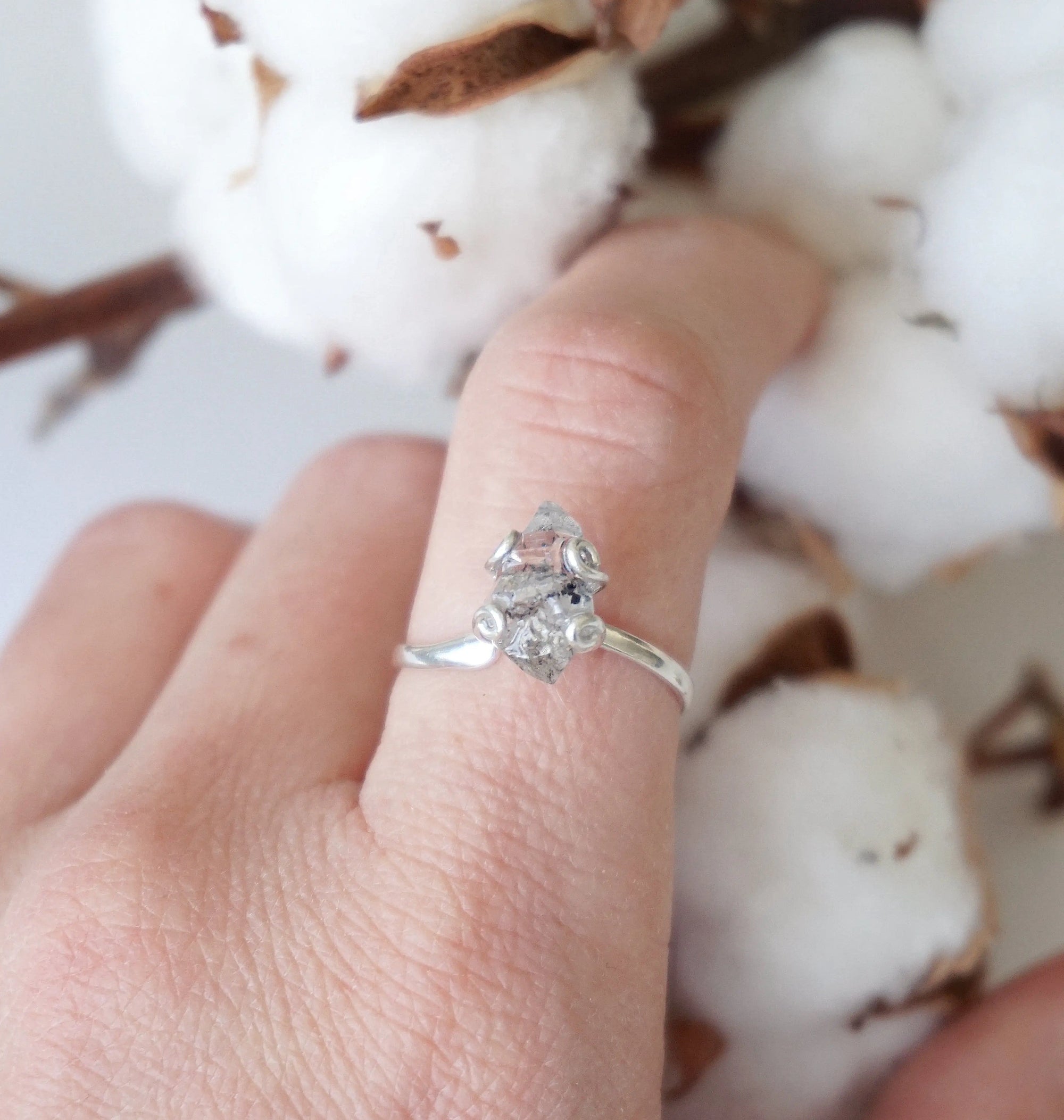 Adjustable raw Herkimer diamond ring in 925 sterling silver worn on a female model’s hand.