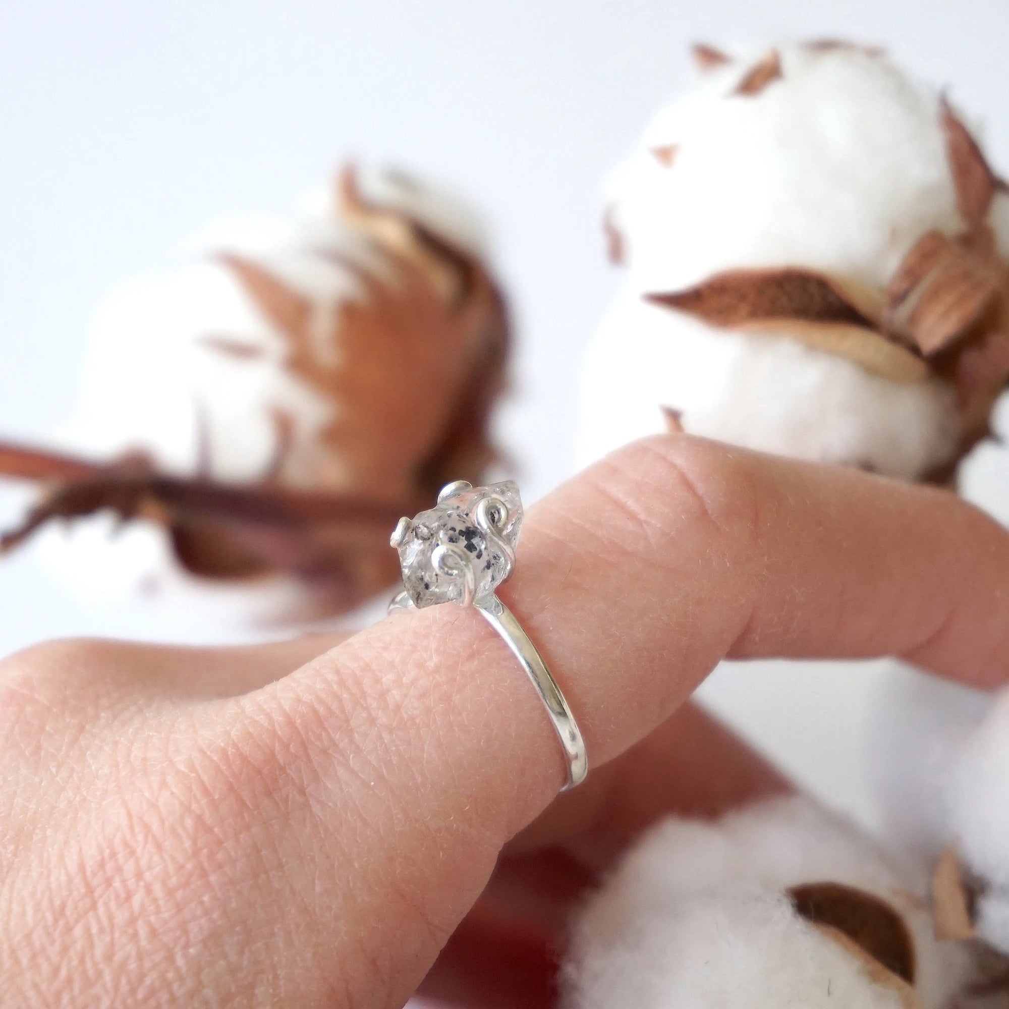 Adjustable raw Herkimer diamond ring in sterling silver styled on a female model’s hand for everyday wear.