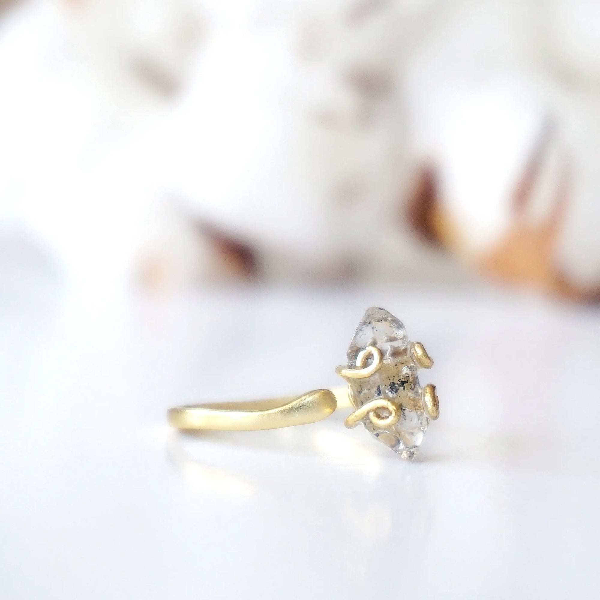 Side angle detail of adjustable raw Herkimer diamond ring in 14k gold vermeil artisan setting.