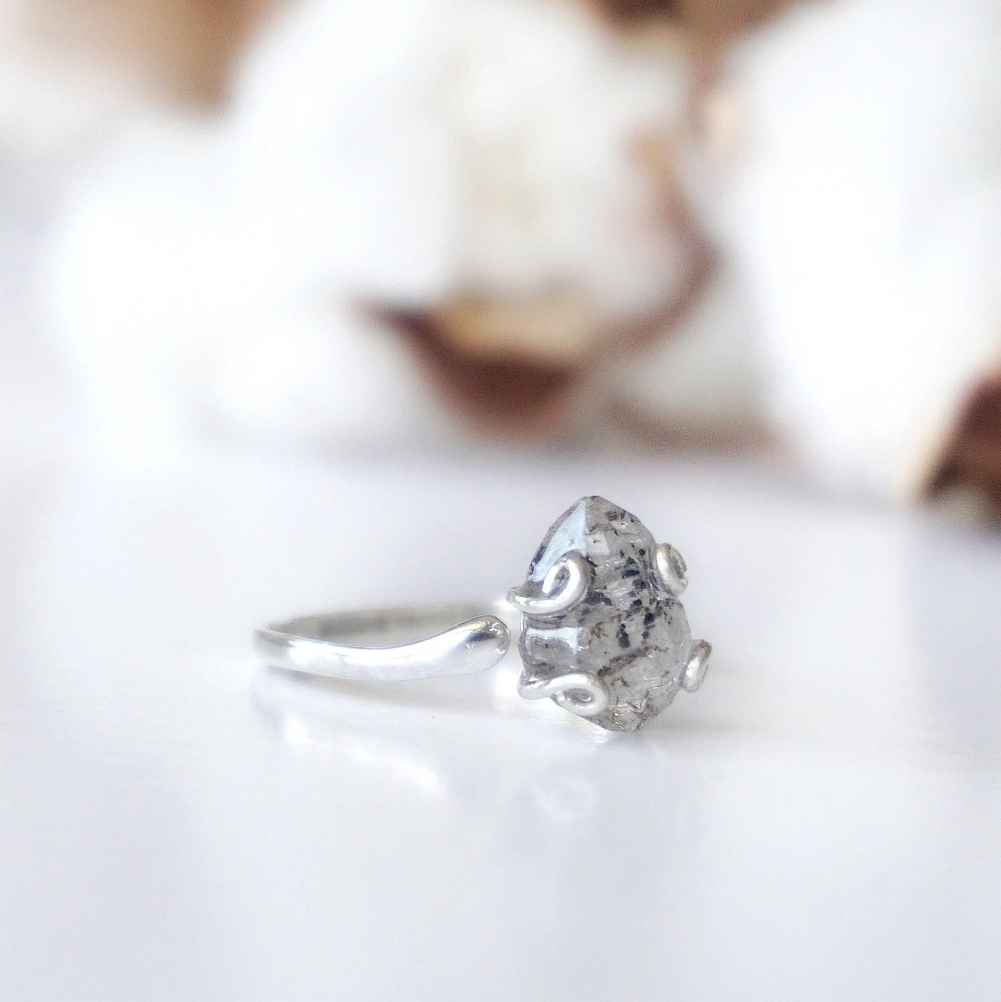 Side angle detail of adjustable raw Herkimer diamond ring in 925 sterling silver artisan setting.