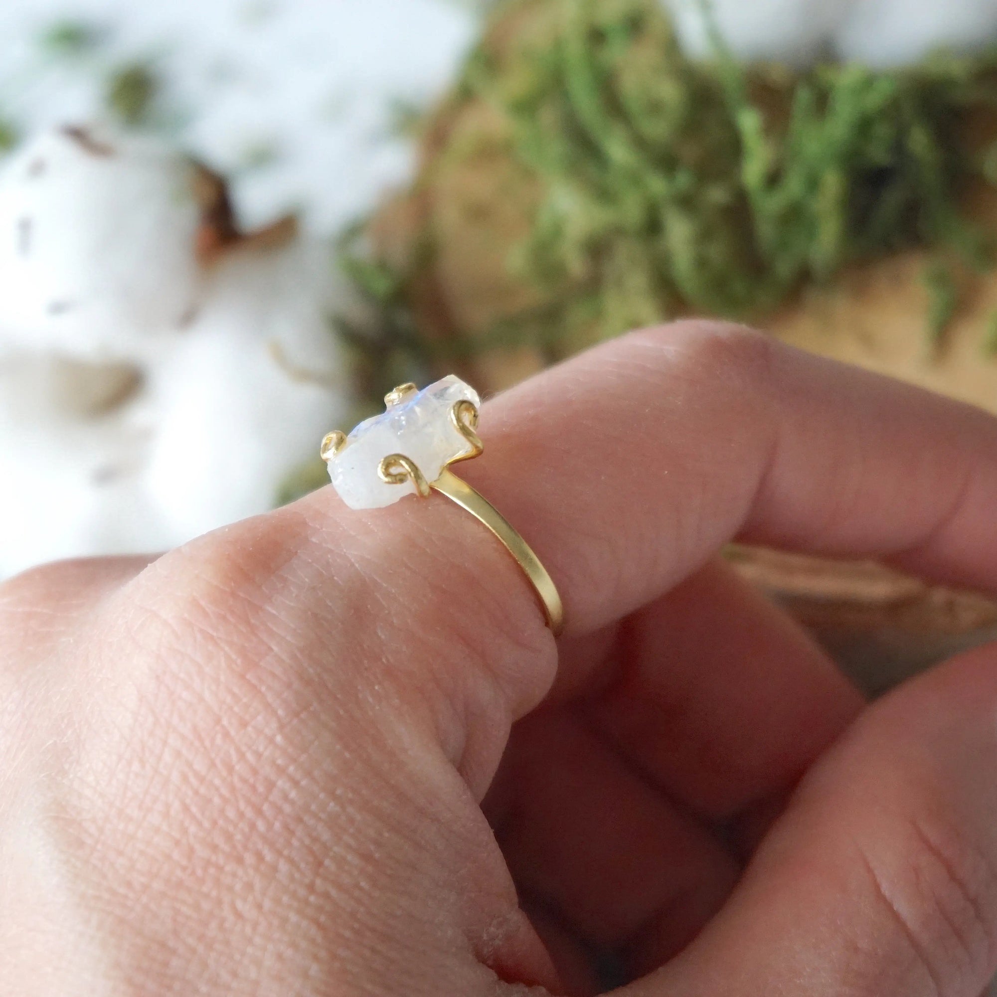 Lifestyle photo of adjustable raw rainbow moonstone ring in 14k gold vermeil on a woman’s hand, minimalist June birthstone jewelry.