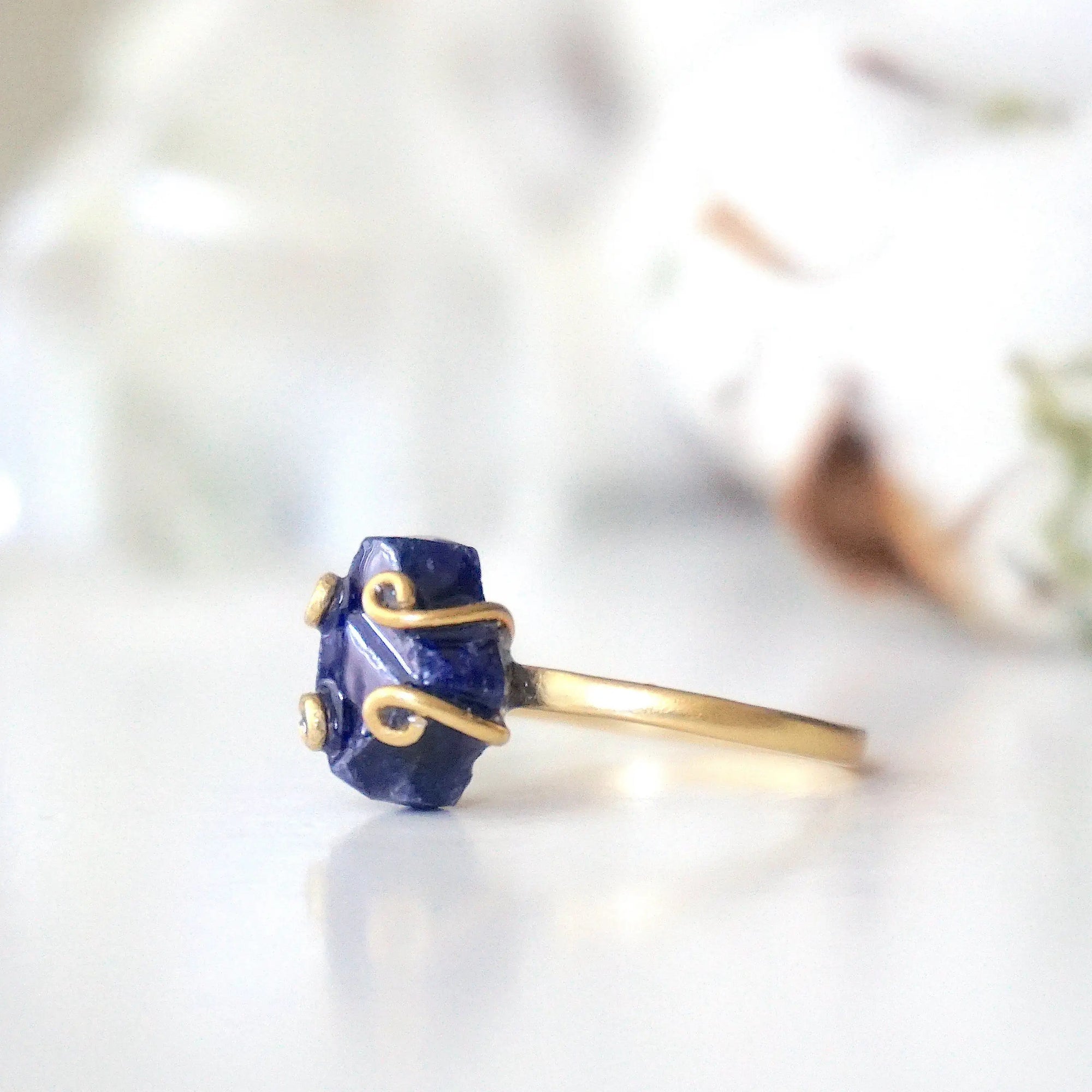 Left-side detail of adjustable raw sapphire ring showing the handcrafted gold vermeil artisan setting