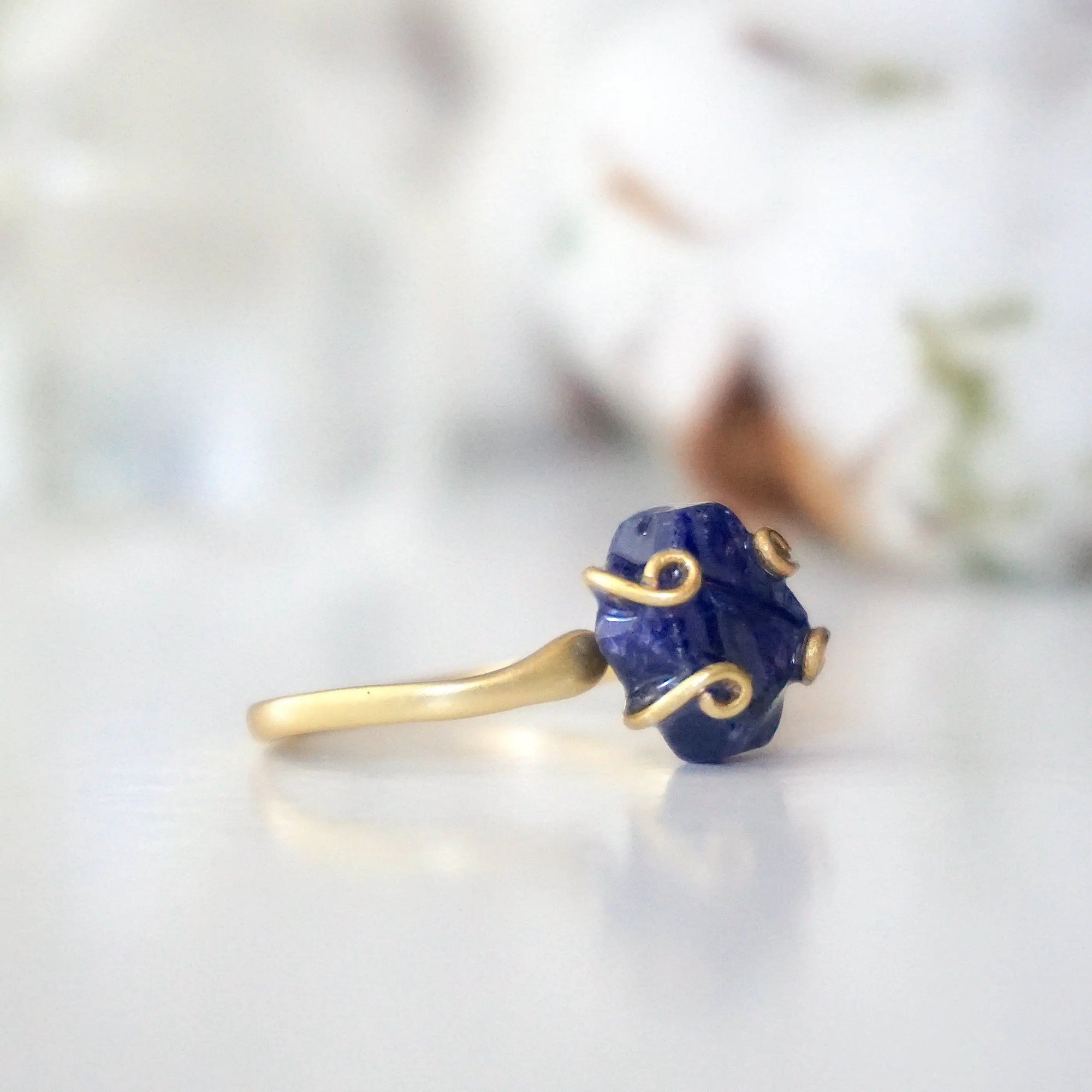 Right-side angle of adjustable raw sapphire ring showing the gold vermeil setting and natural stone profile
