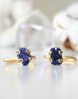 Two adjustable raw sapphire rings showing natural variation in stone size, shape, markings, and blue colour — each ring is one of a kind
