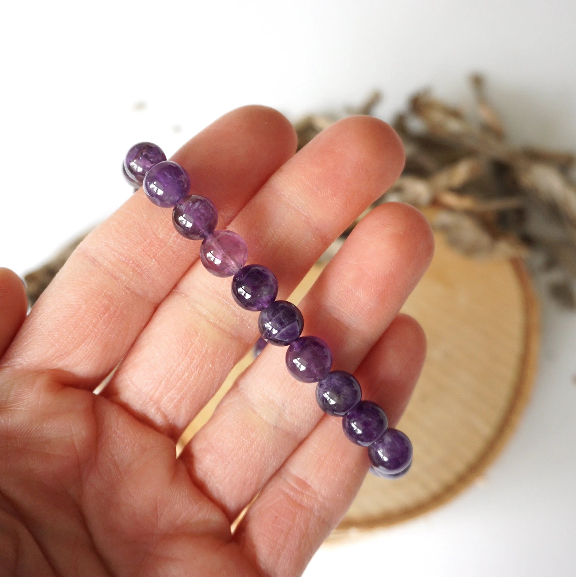 Amethyst beaded stretch bracelet in hand for size reference, natural 8mm amethyst beads