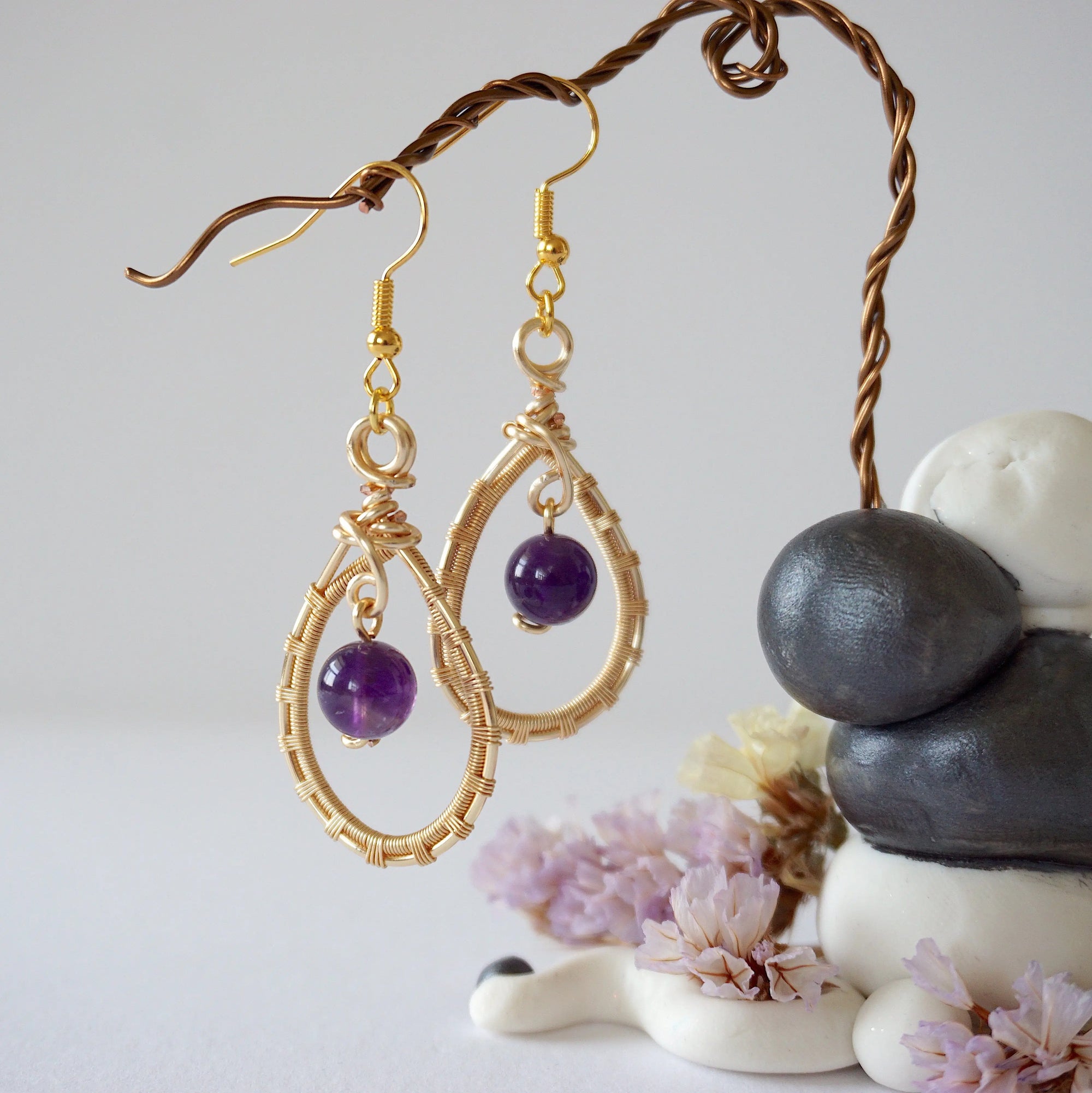 Front view of amethyst drop earrings with 8mm polished amethyst bead in gold plated copper wire wrapped teardrop dangle design