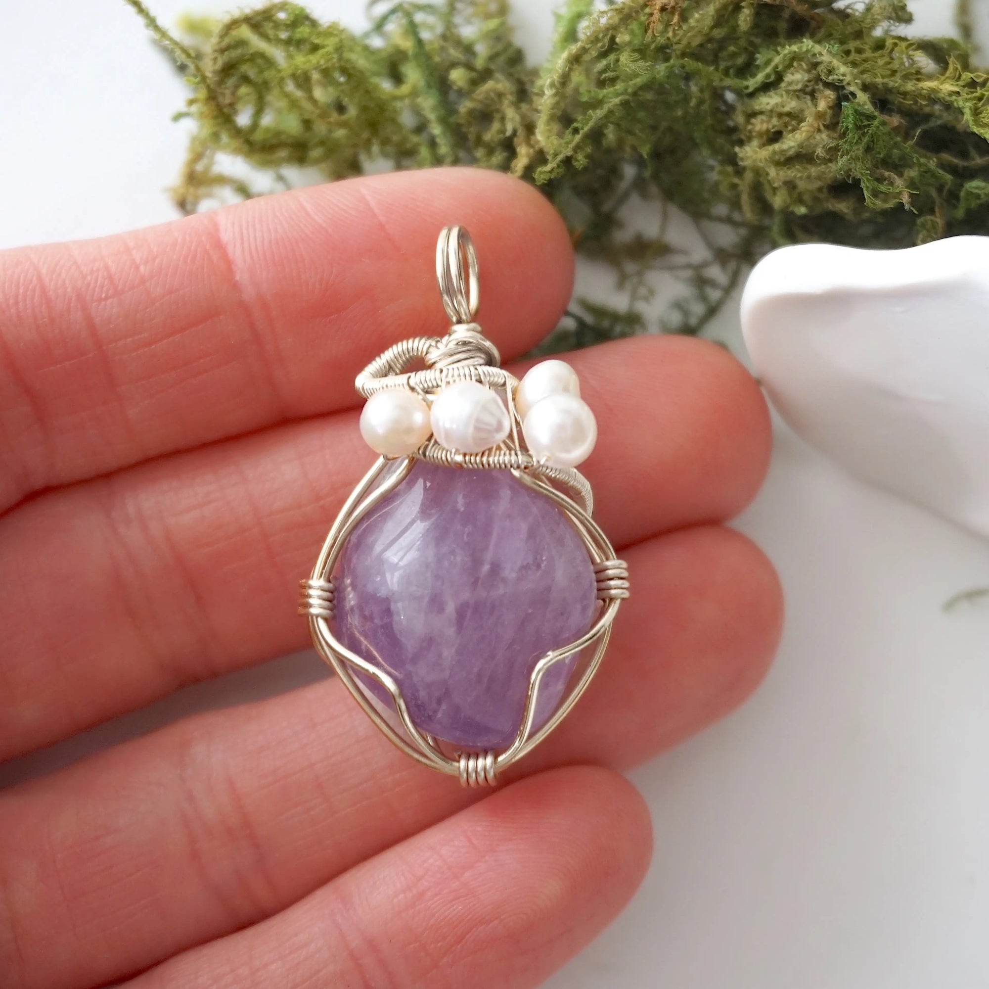 Amethyst and freshwater pearl pendant necklace in hand for size reference, silver wire wrapped, handcrafted gemstone jewelry