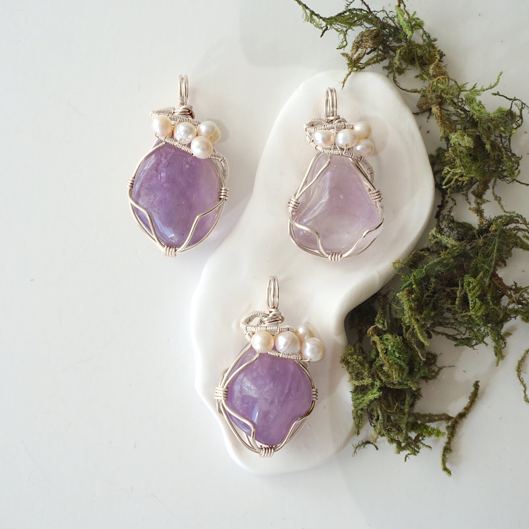 Three silver wire wrapped amethyst and freshwater pearl pendants showing natural stone variation, artisan jewelry for women