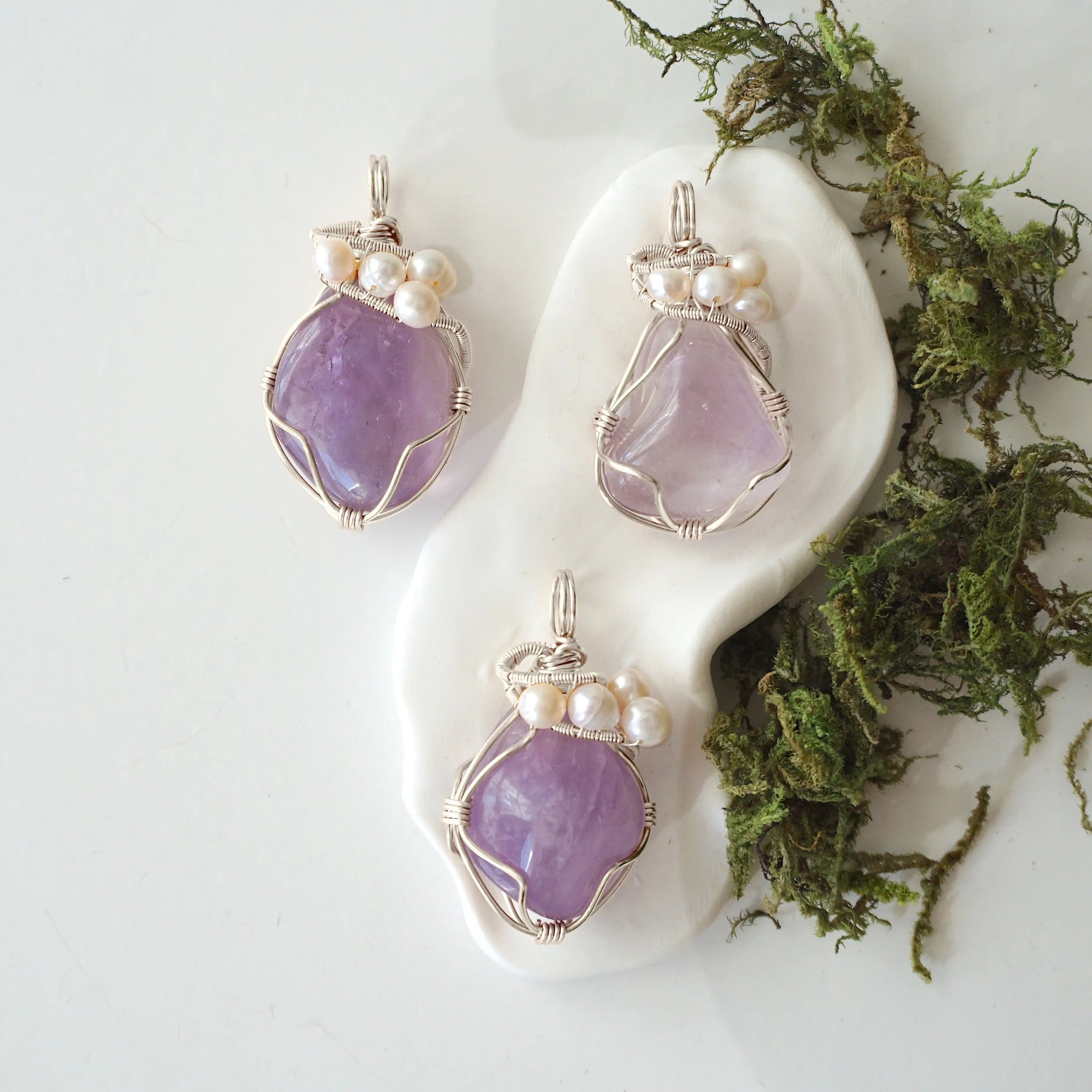 Three silver wire wrapped amethyst and freshwater pearl pendants showing natural stone variation, artisan jewelry for women