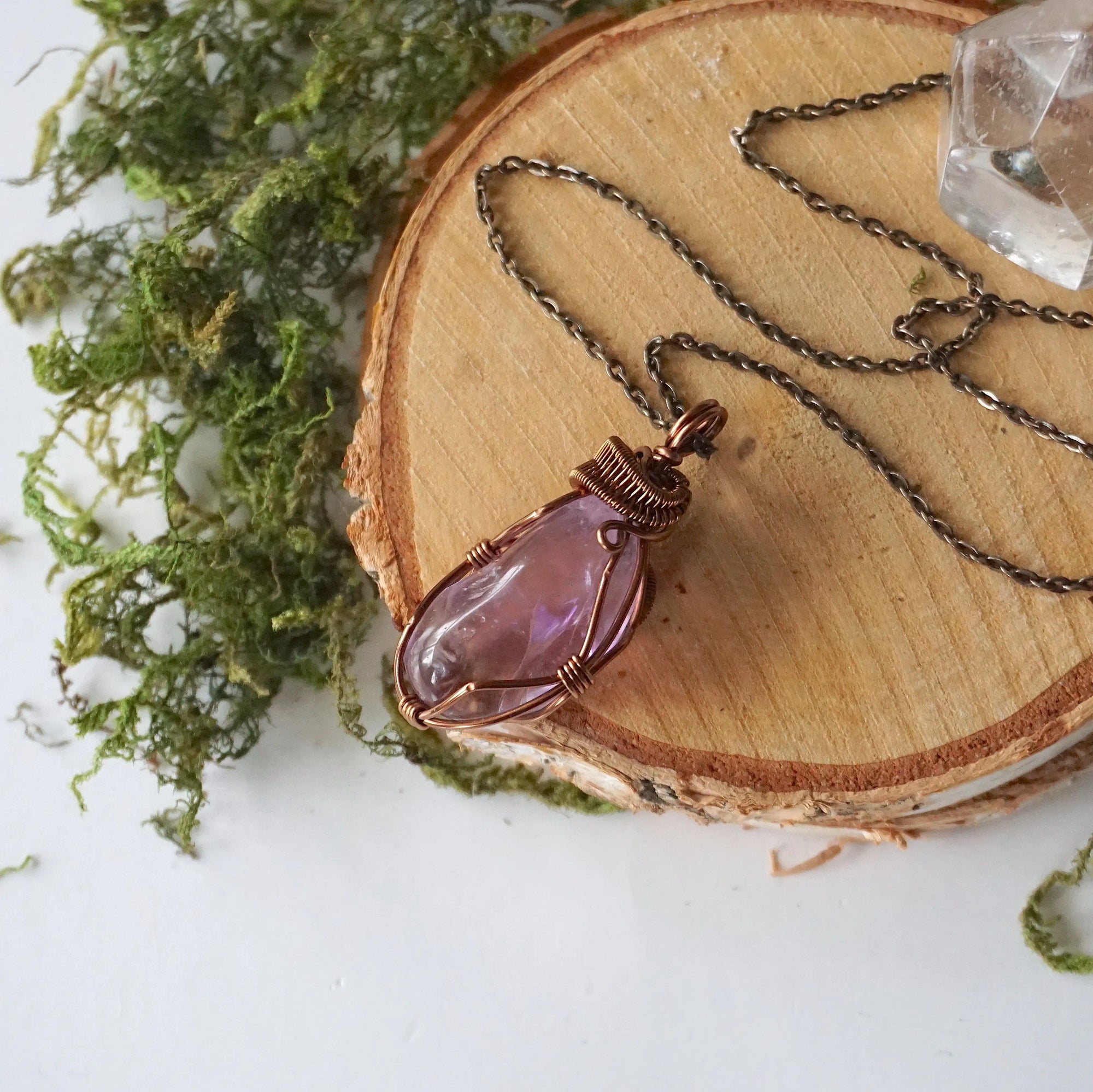 Detailed front view of women’s amethyst pendant, lighter violet stone, artisan wire wrapped in antique bronze copper