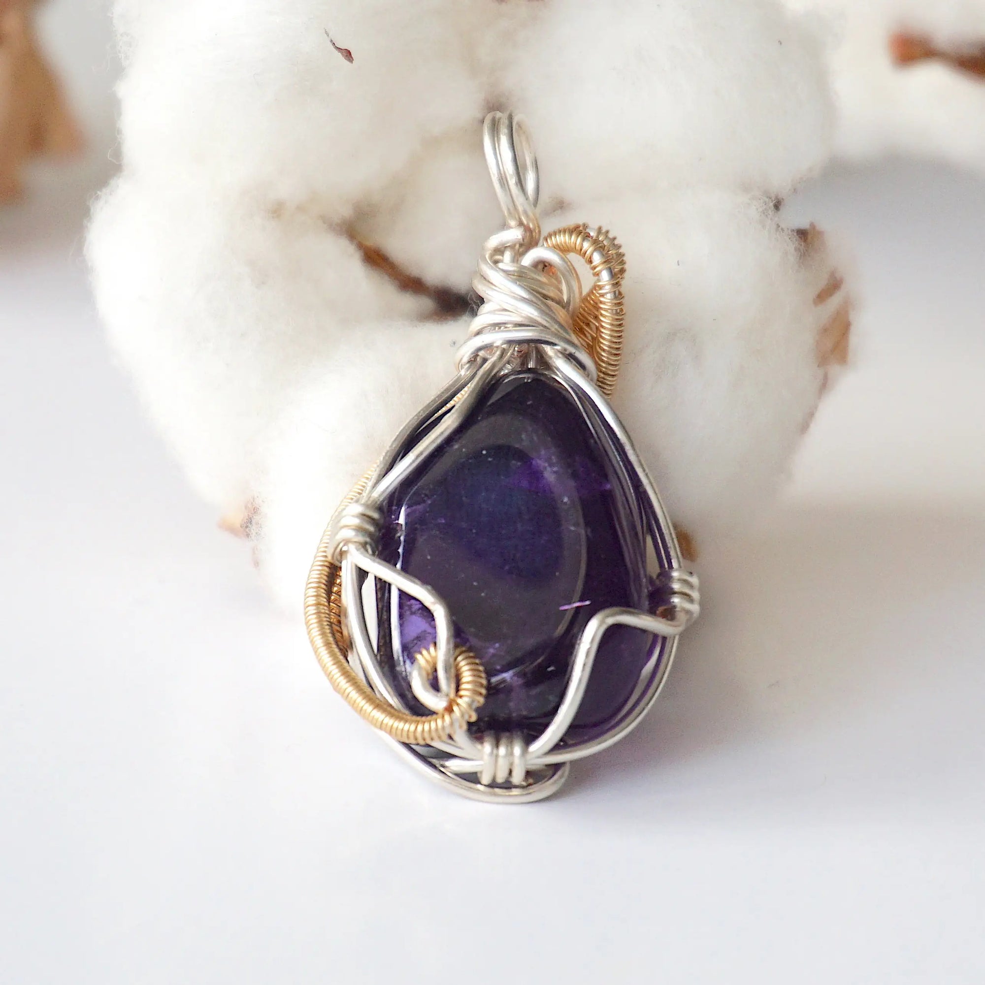 Back side angle of women’s amethyst pendant, polished dark amethyst, silver and gold plated copper artisan wire wrap
