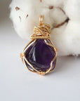 Back side angle of women’s gold amethyst necklace, polished dark amethyst pendant, artisan gold plated copper wire wrap