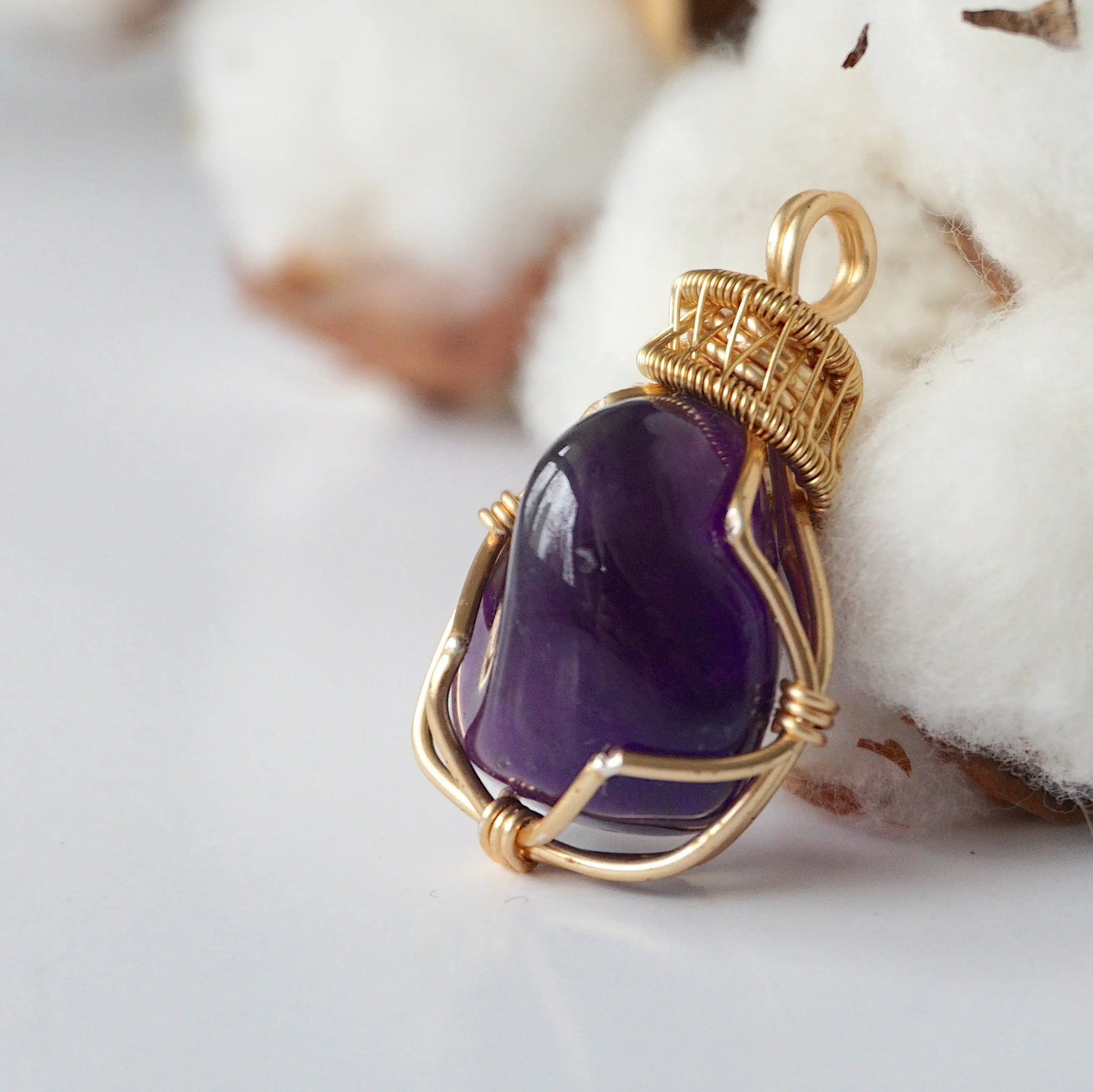 Left side angle of women’s gold amethyst necklace, polished dark amethyst pendant, artisan gold plated copper wire wrap