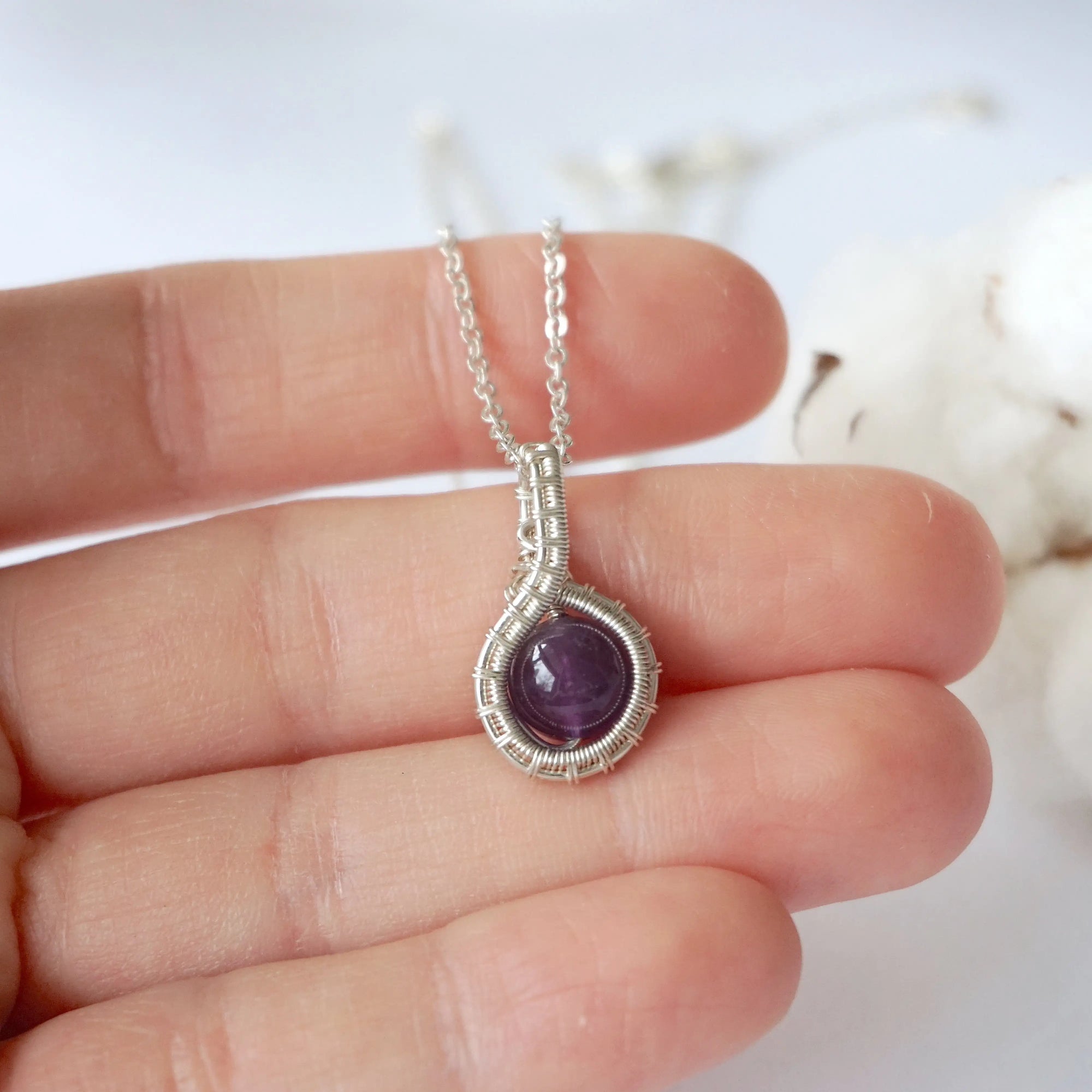 Women’s silver amethyst necklace in hand for size reference, 8mm amethyst bead, artisan silver plated copper wire wrap