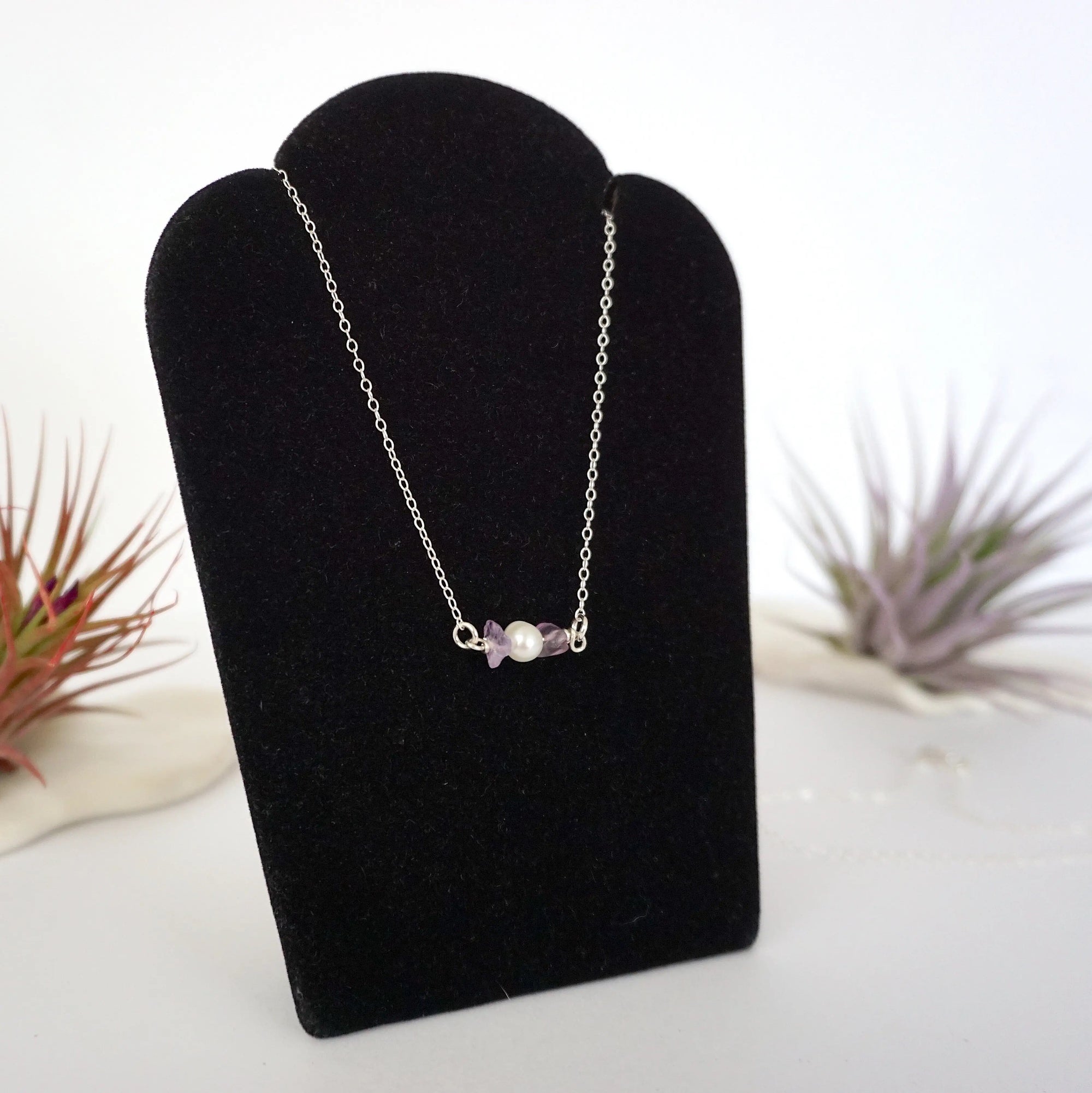 Right angle view of amethyst and freshwater pearl bar necklace in 925 sterling silver on jewelry display