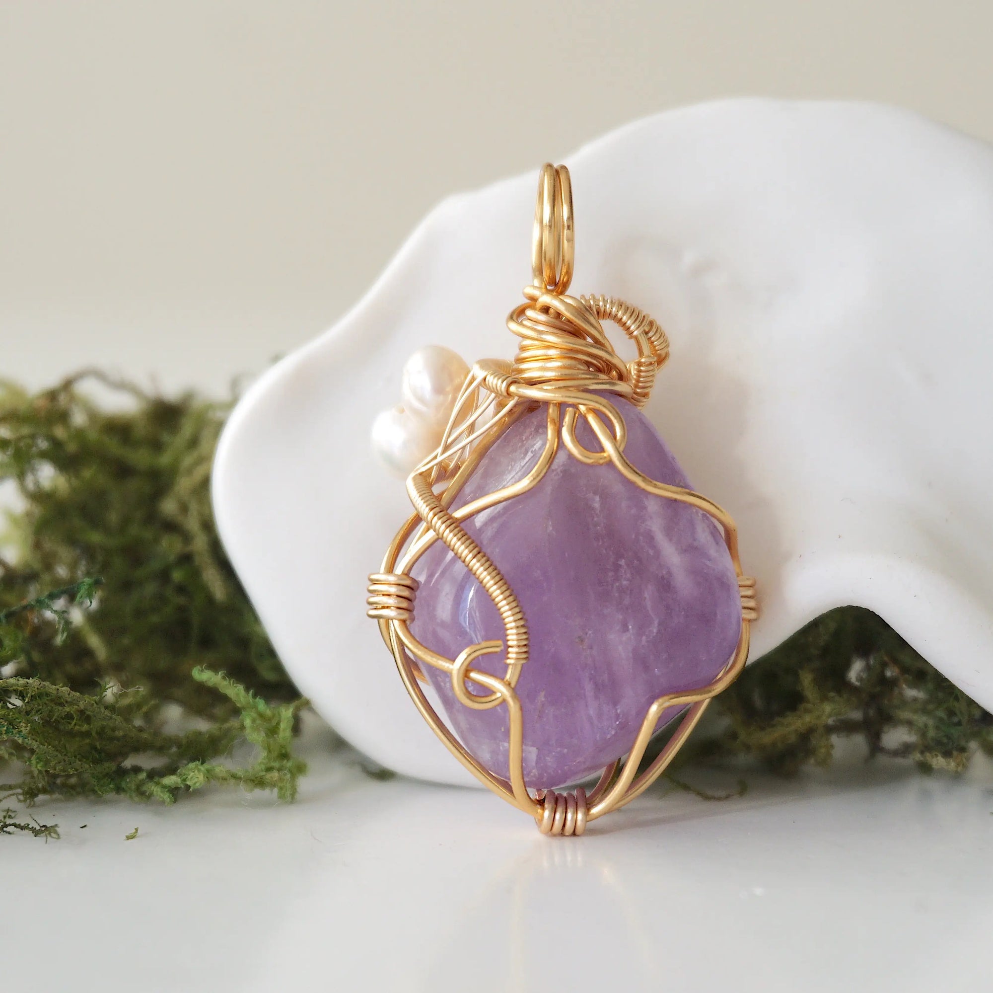Back angle detail of amethyst and freshwater pearl pendant, showing wire wrapping and natural stone