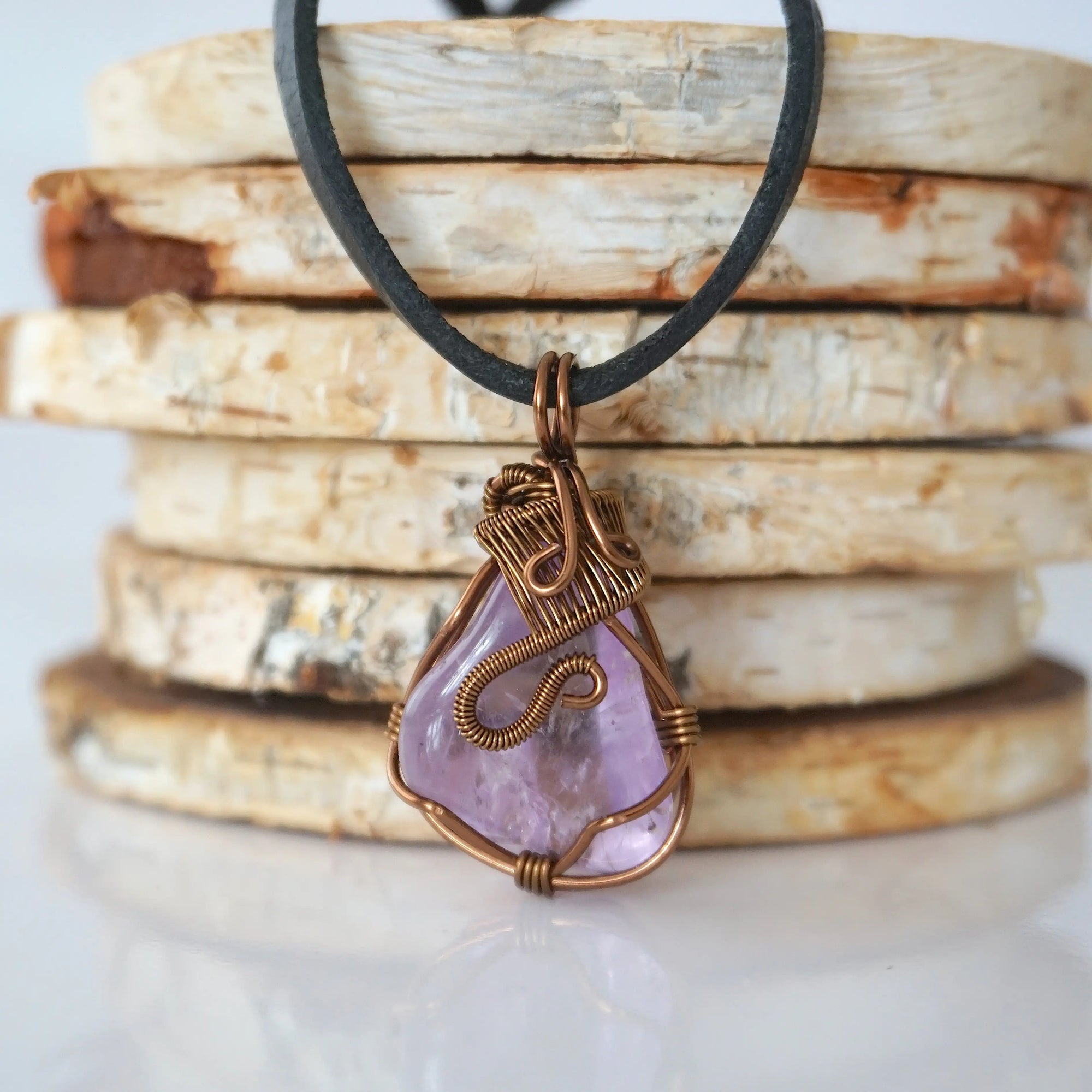 Back view of mens amethyst wire wrapped pendant — bronze copper finish hand-wrapped setting shows craftsmanship and secure stone hold, handmade in Toronto Canada