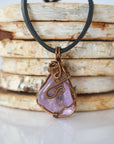 Back view of mens amethyst wire wrapped pendant — bronze copper finish hand-wrapped setting shows craftsmanship and secure stone hold, handmade in Toronto Canada