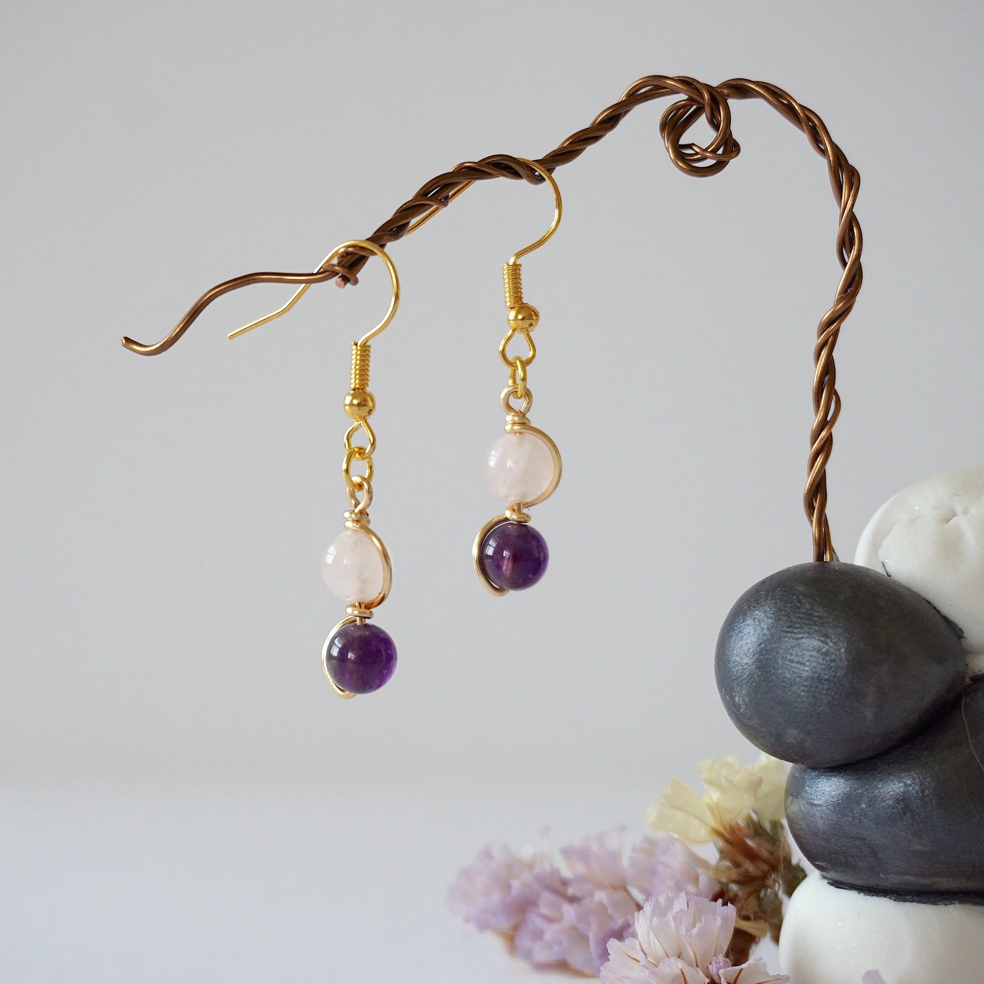 Front view of amethyst and rose quartz drop earrings with 6mm polished beads, gold plated copper wire wrapped dangle design