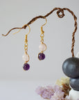 Front view of amethyst and rose quartz drop earrings with 6mm polished beads, gold plated copper wire wrapped dangle design