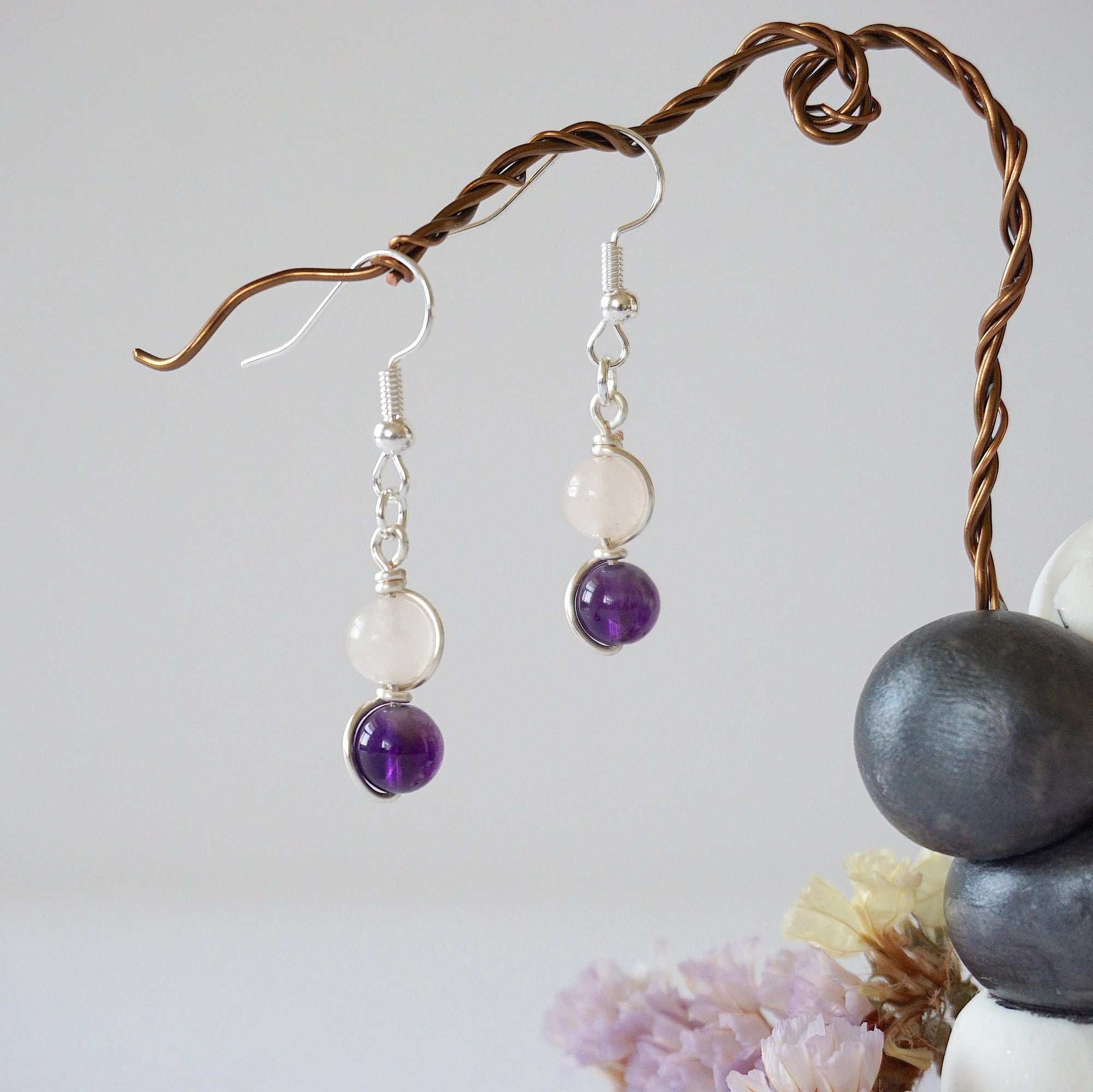 Front view of amethyst and rose quartz drop earrings with 6mm polished beads, silver plated copper wire wrapped dangle design