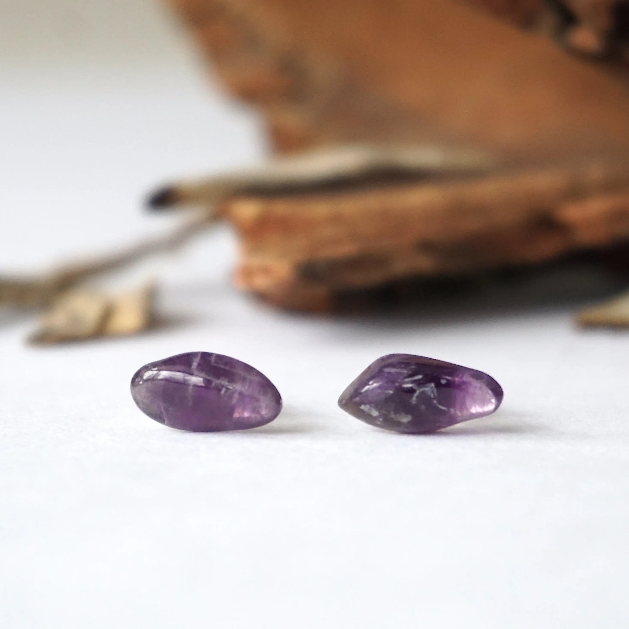 Detailed front view of natural dark amethyst stud earrings, polished amethyst stones on sterling silver posts