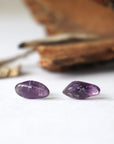 Detailed front view of natural dark amethyst stud earrings, polished amethyst stones on sterling silver posts