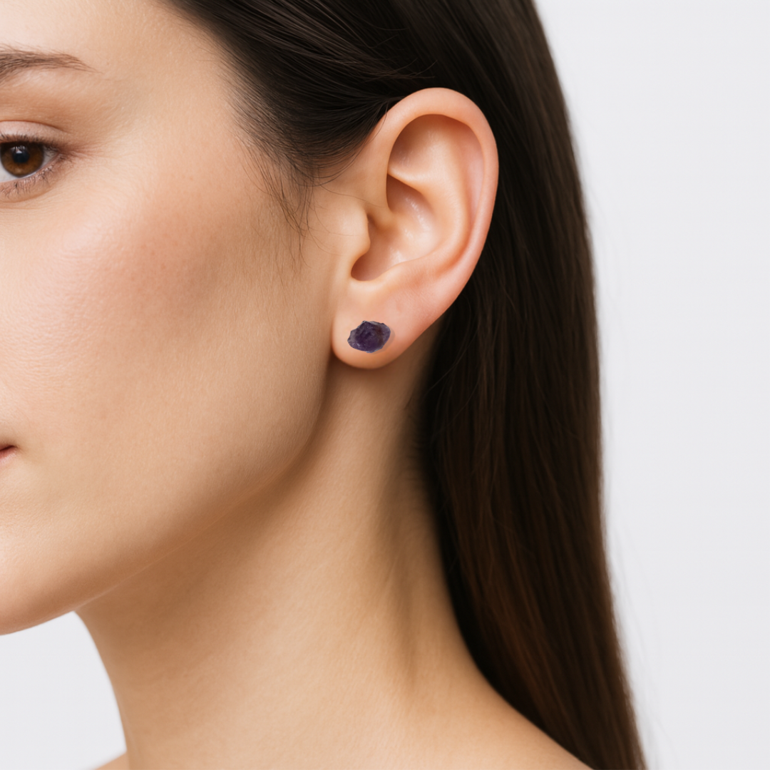 Amethyst stud earrings worn on female model's ear, natural dark amethyst stones, sterling silver posts