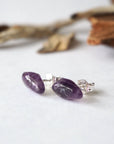 Side angle view of amethyst stud earrings, natural dark amethyst stones, sterling silver posts